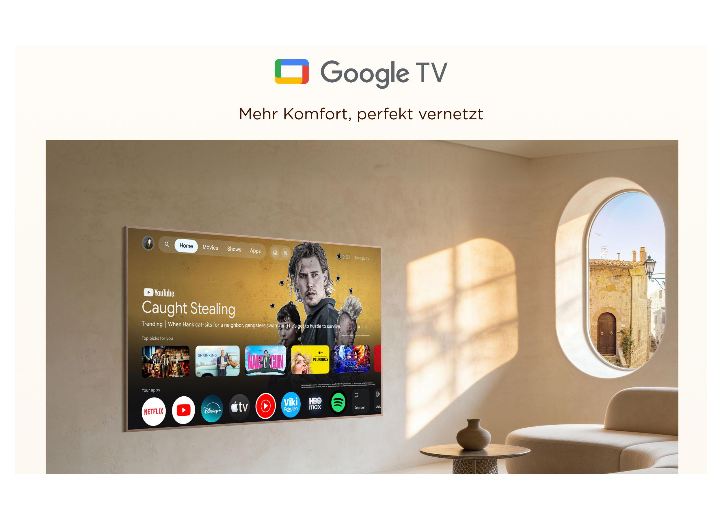 Ein Google TV an einer beige Wand zeigt die Benutzeroberfläche, während Sonnenlicht durch ein Rundfenster fällt.