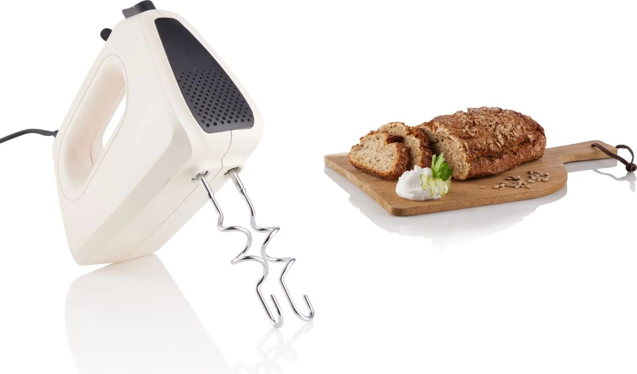 Kézi mixer dagasztóhorgokkal egy vágódeszka mellett, szeletelt kenyérrel és krémmel.