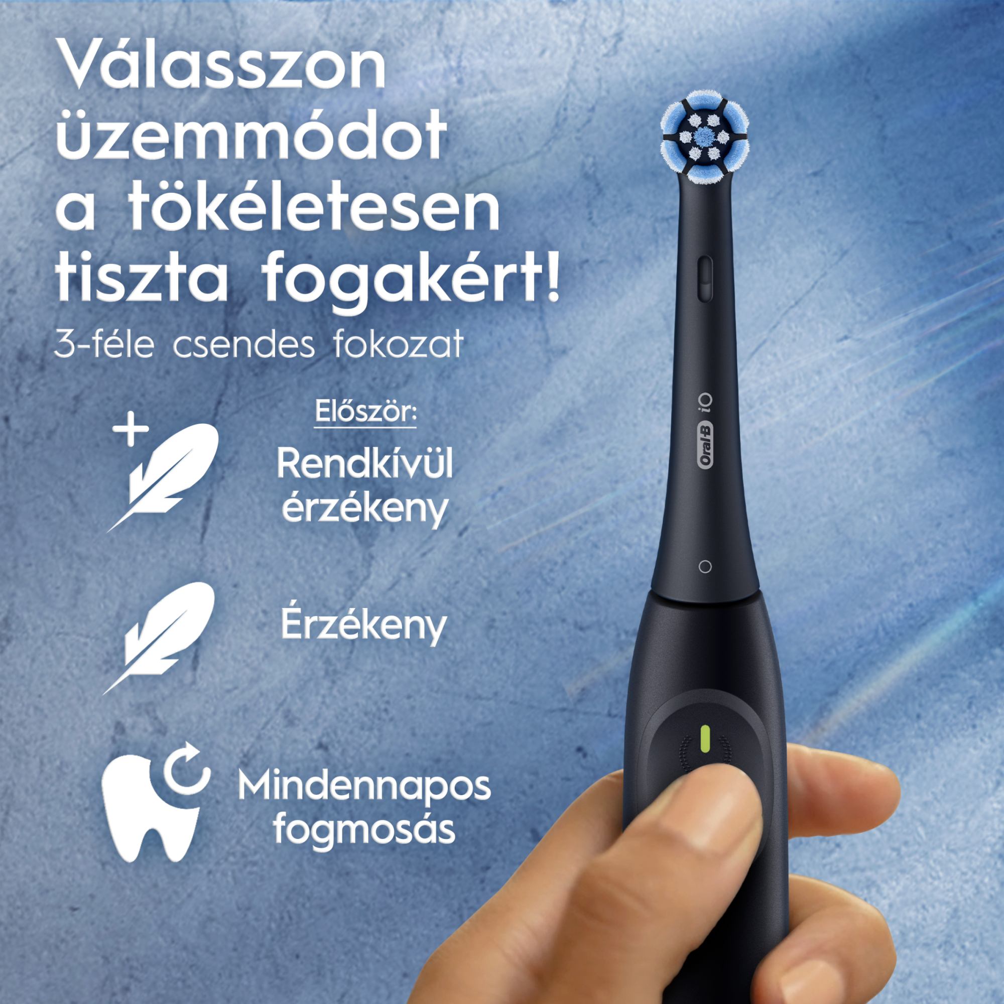 Kéz tart egy fekete Oral-B iO elektromos fogkefét három üzemmód ikonnal kék háttér előtt.