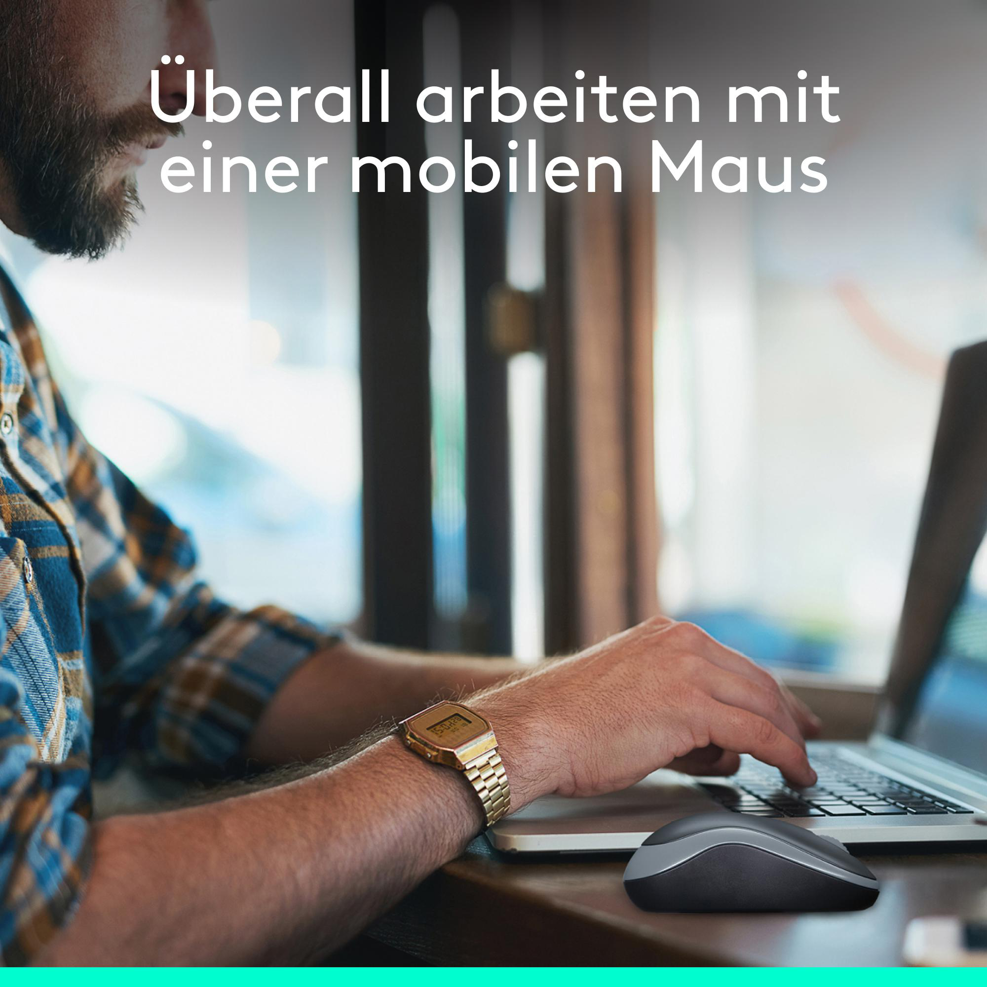Ein Mann tippt an einem Laptop, daneben liegt eine graue Computermaus.