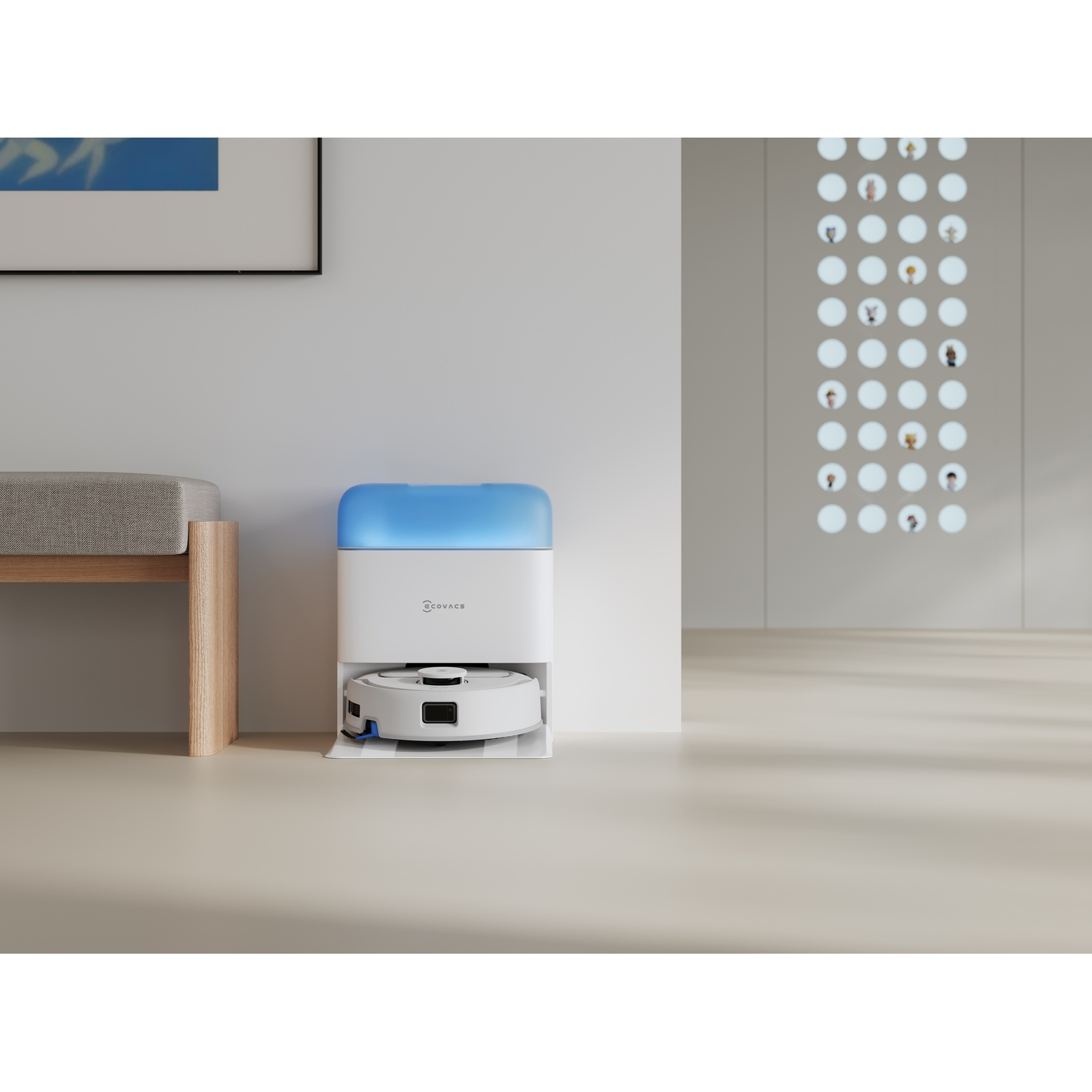Un robot aspirapolvere bianco nella sua stazione di ricarica con luce blu si trova in una stanza moderna.