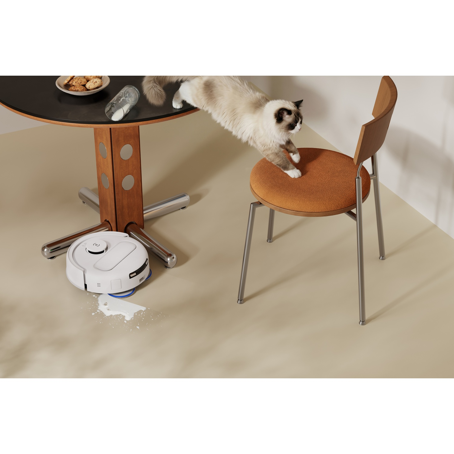 Un gatto salta dal tavolo a una sedia, mentre un robot aspirapolvere pulisce del latte.