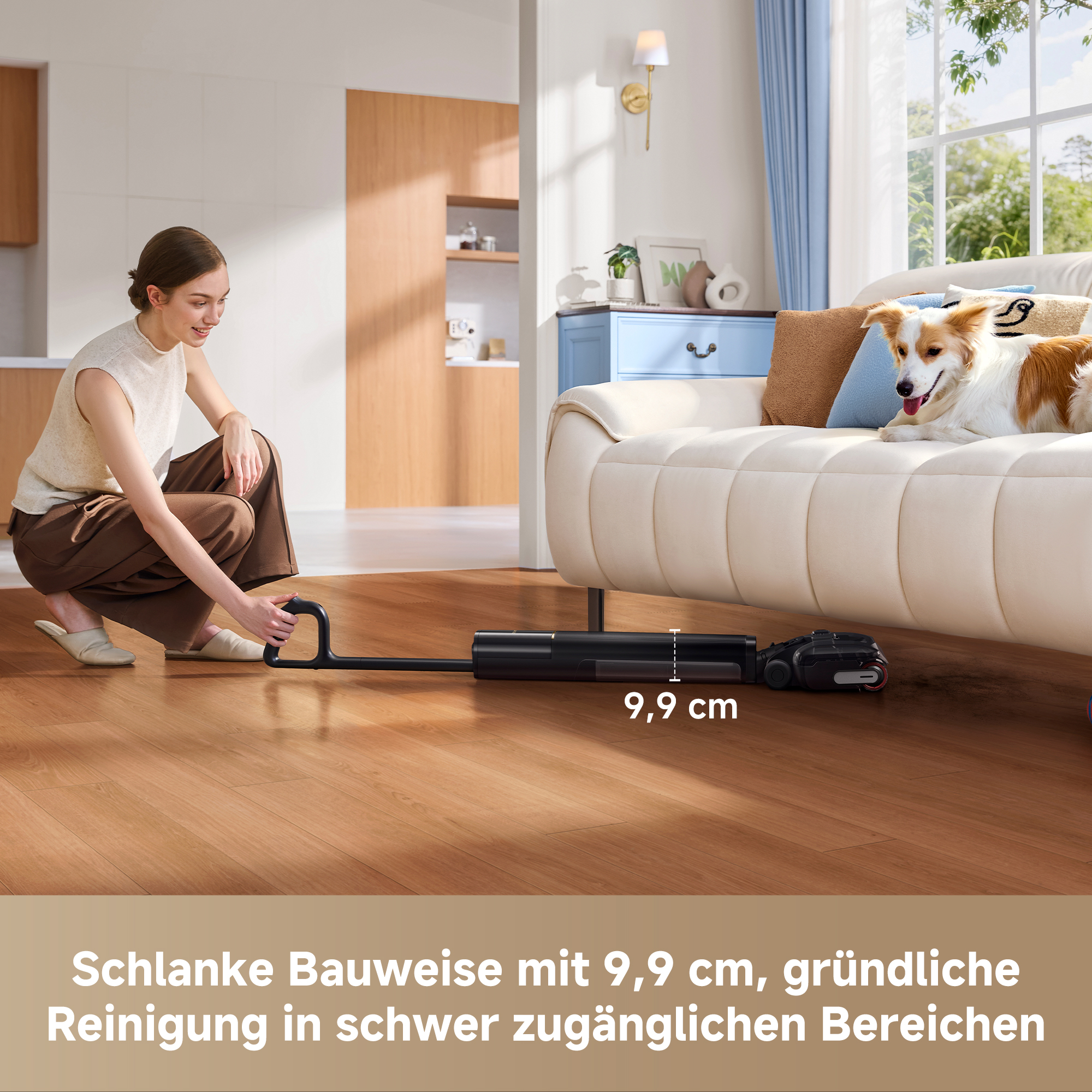 Eine Frau benutzt einen schlanken schwarzen Staubsauger unter einem weißen Sofa, auf dem ein Hund ruht.