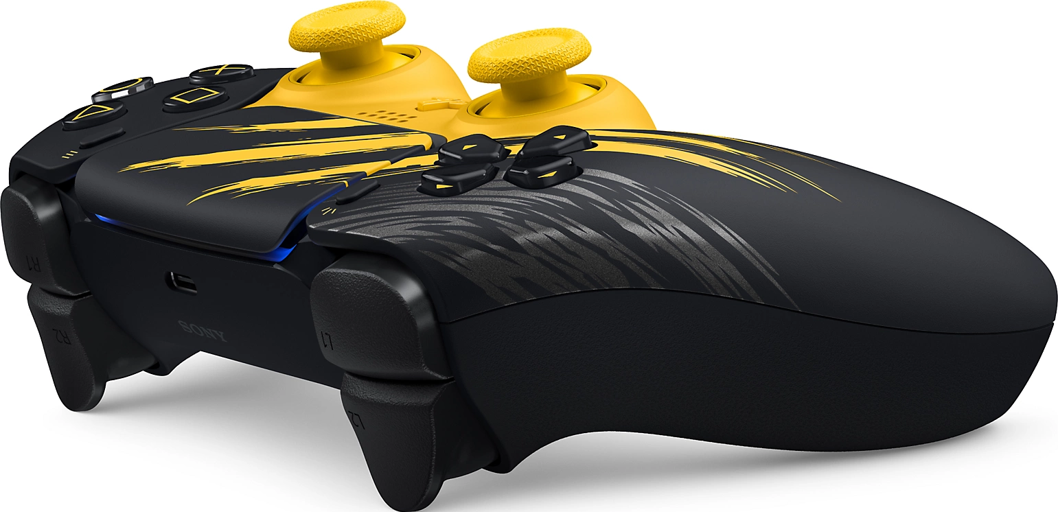Manette PlayStation noire et jaune avec des motifs de pinceau abstraits sur fond blanc.
