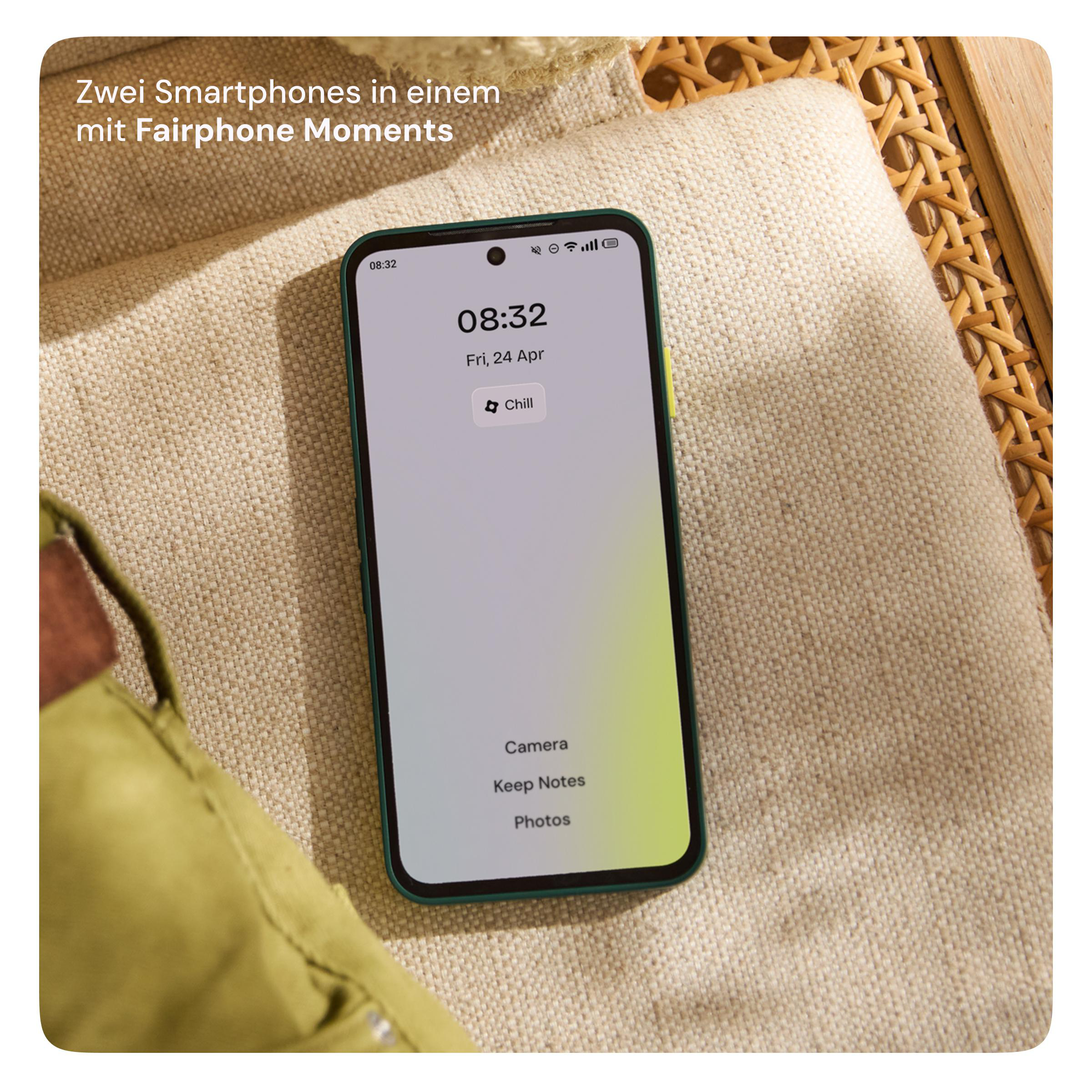 Ein Smartphone mit grünem Gehäuse liegt auf einem beigen Kissen auf einer Rattan-Oberfläche.
