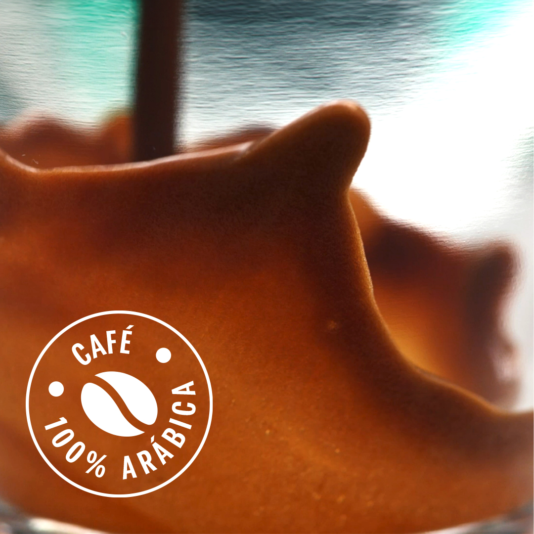 Café recién hecho con espuma, con un logotipo redondo que dice Café 100% Arábiga.