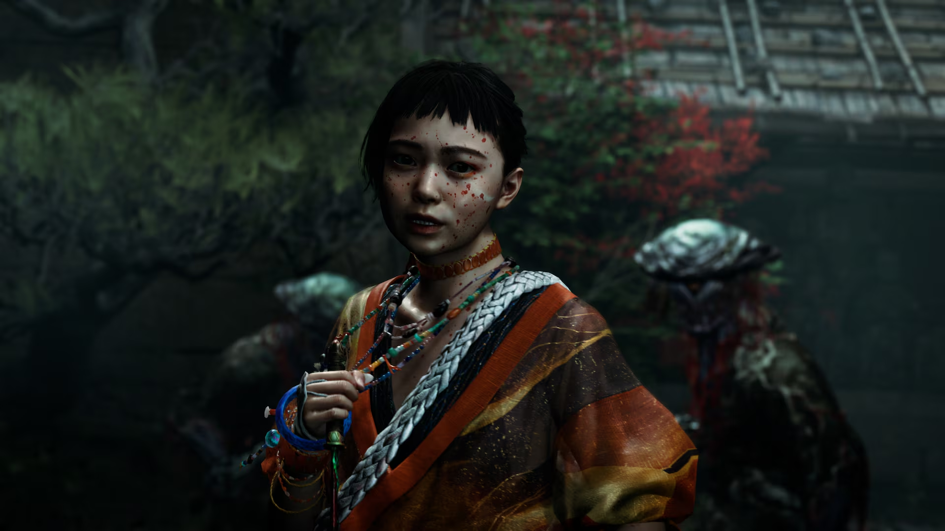 Une fille aspergée de sang avec des perles colorées et un kimono orange se tient sur un fond sombre.