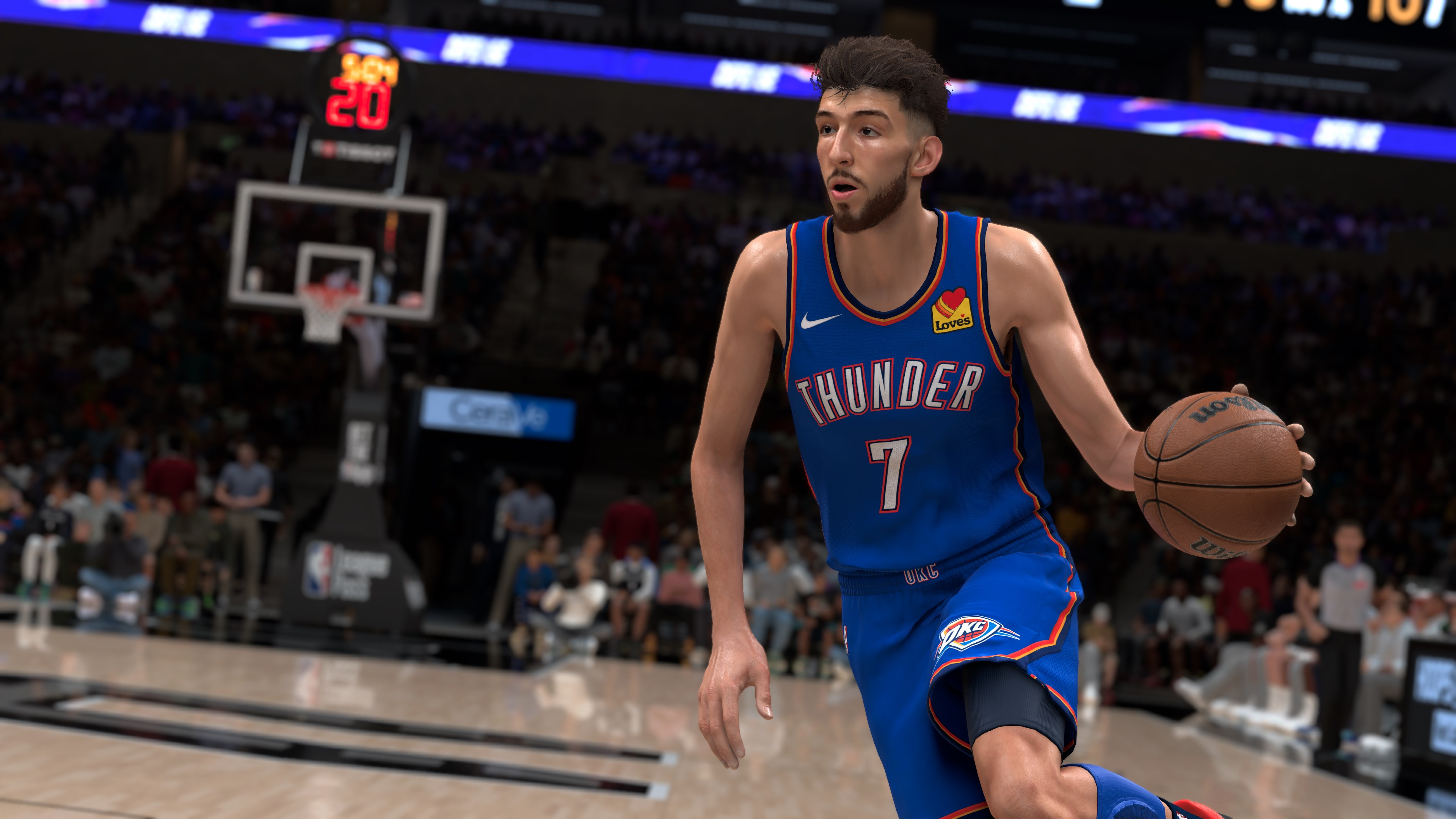 Un giocatore di basket con maglia blu dei Thunder palleggia in un'arena gremita.