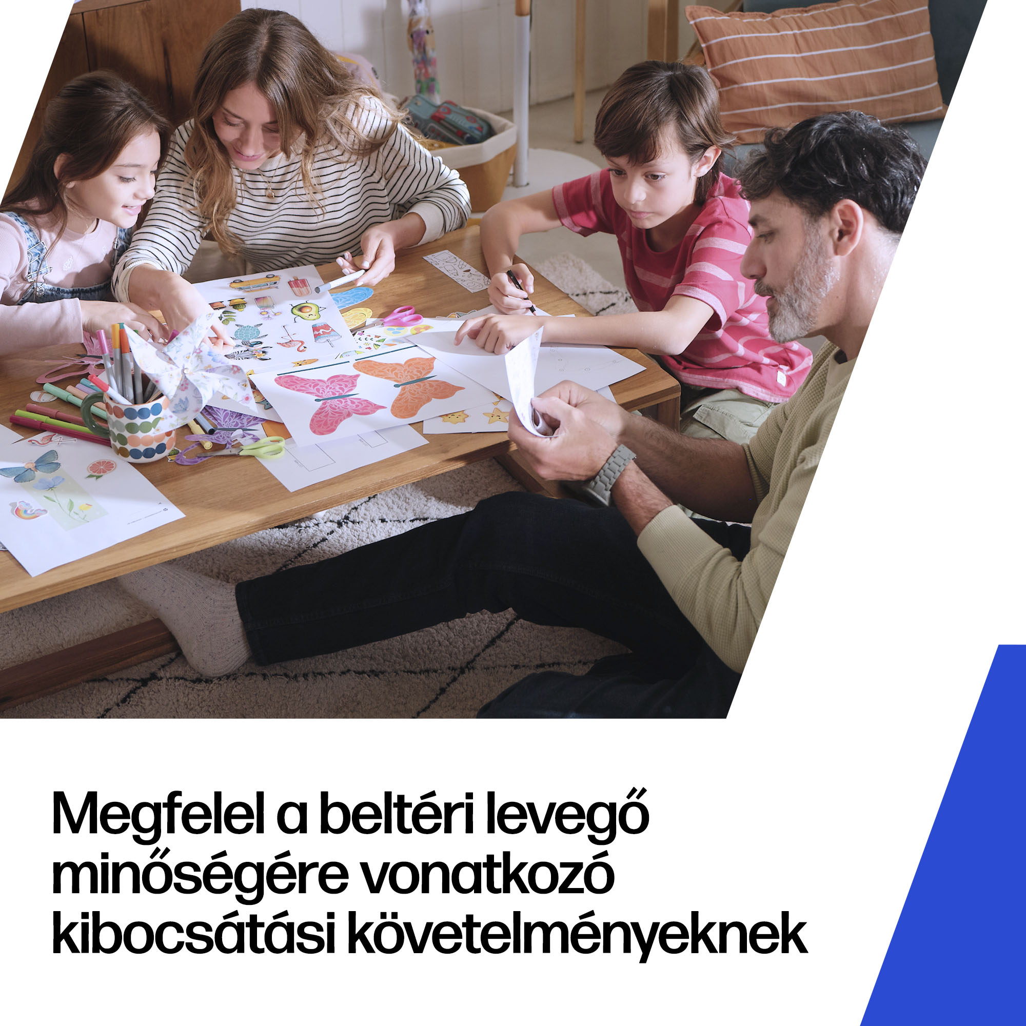 Egy négytagú család egy fa dohányzóasztal körül ül, rajzolnak és kézműveskednek egy világos nappaliban.