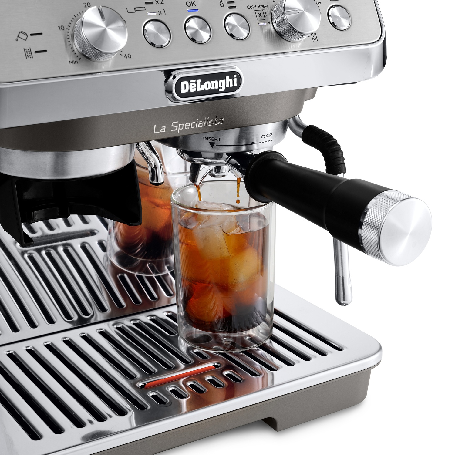 Een DeLonghi espressomachine zet koffie in een glas met ijsblokjes op een lekbak.