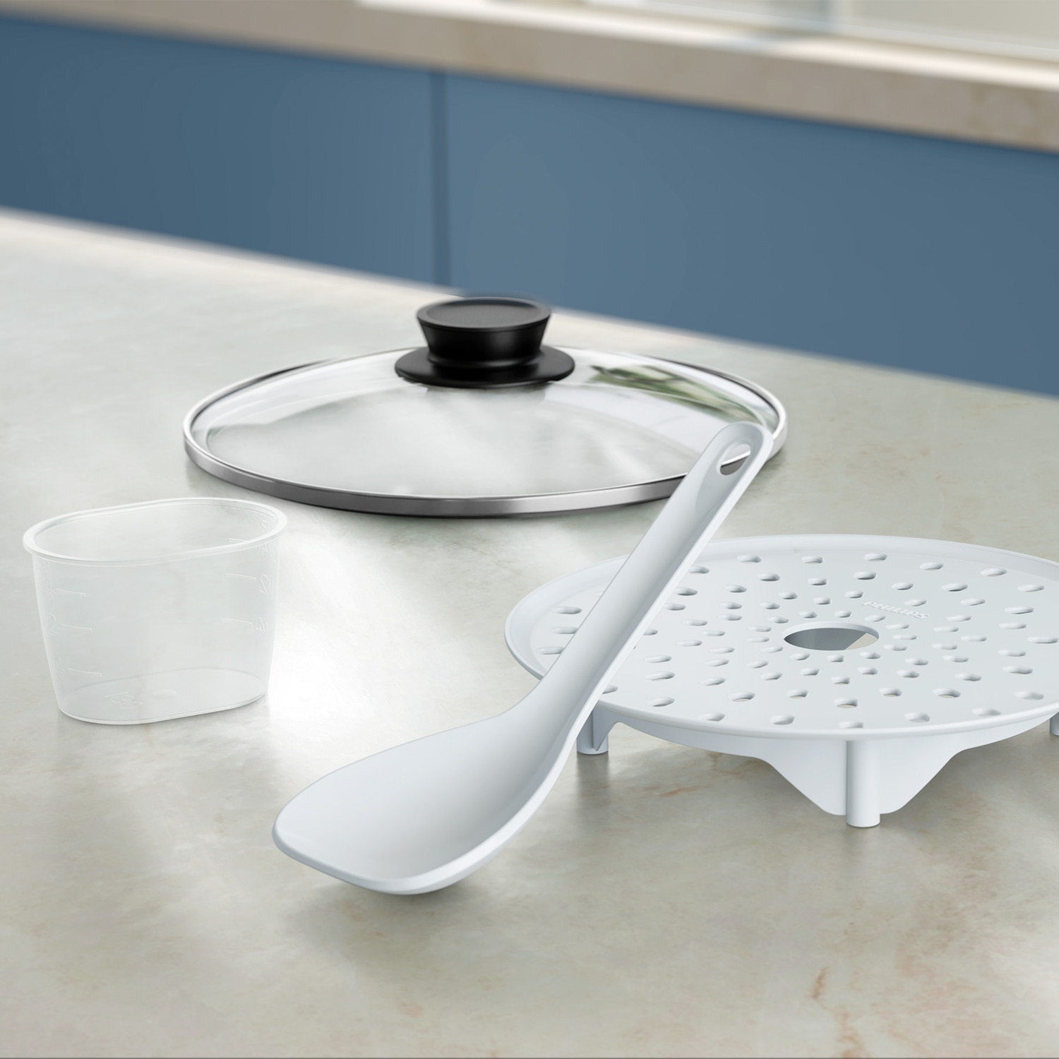 A glass lid, a measuring cup, a spatula, and a steaming tray on a kitchen counter.