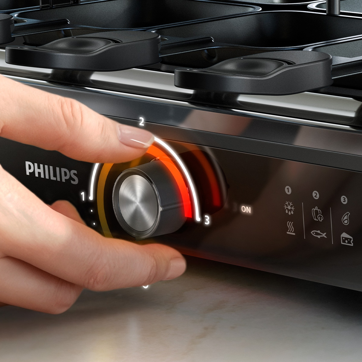 Hand turning the control dial on a black Philips appliance.