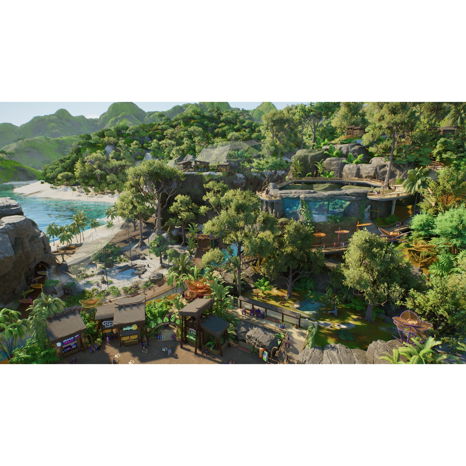 Vue aérienne d'un zoo tropical luxuriant avec des sentiers, des arbres, des falaises et un océan bleu.