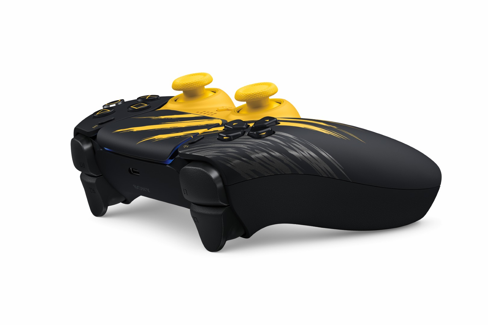 Czarno-żółty kontroler PlayStation z żółtymi drążkami i dynamicznym wzorem na białym tle.
