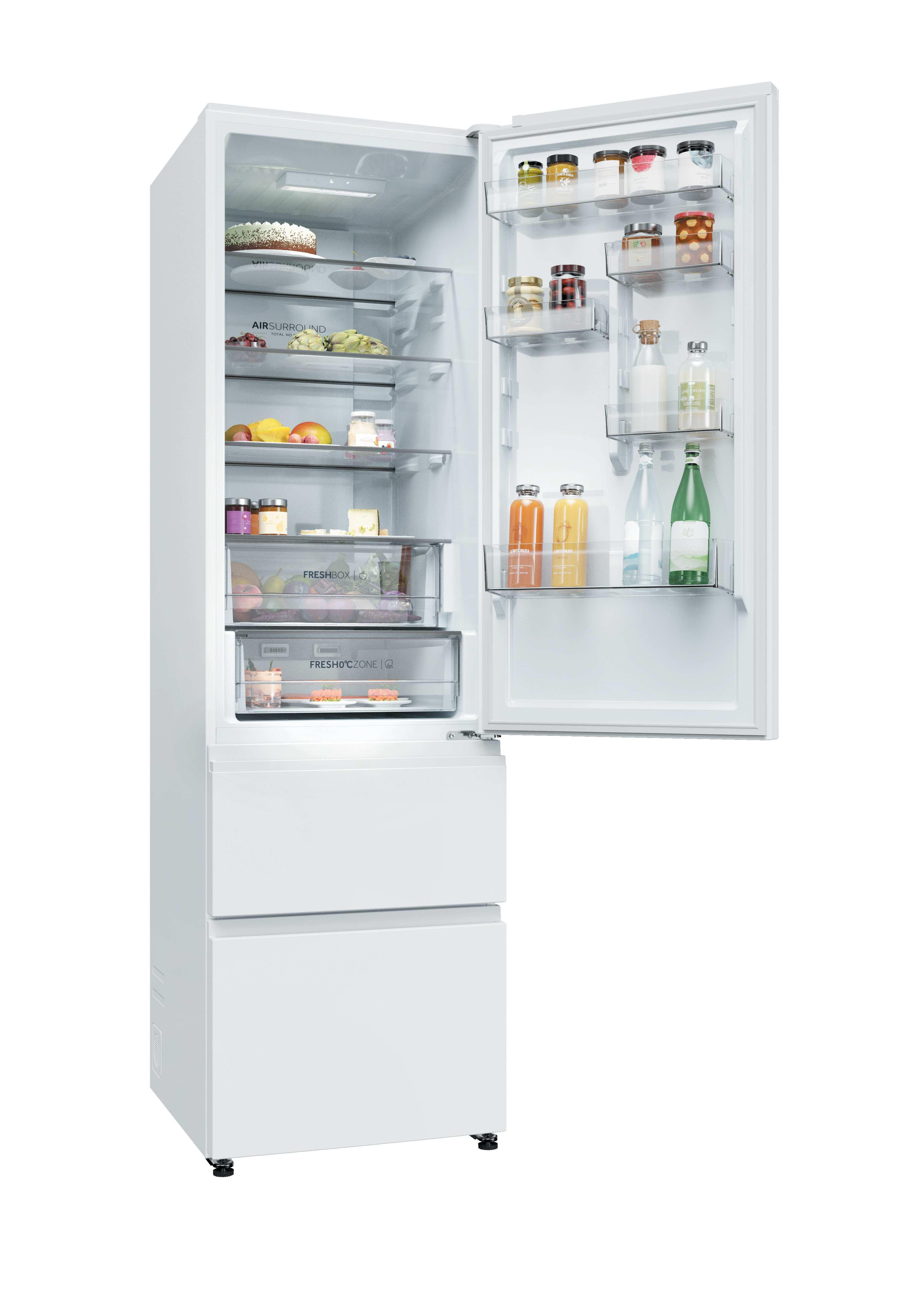 Un refrigerador blanco y abierto con comida en los estantes y dos cajones de congelador abajo.