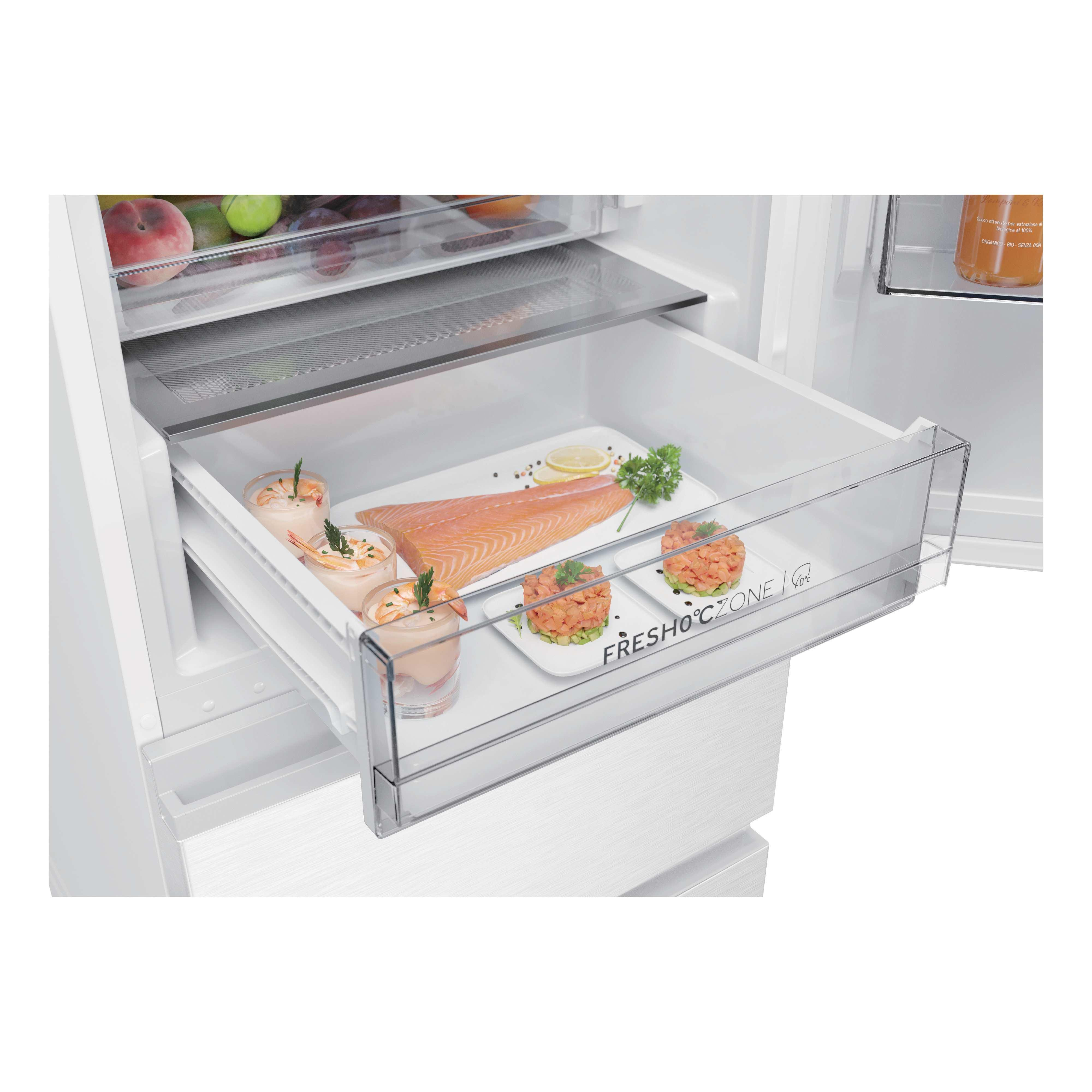 Un cajón abierto en el refrigerador con salmón crudo, camarones en vasos y tartar.