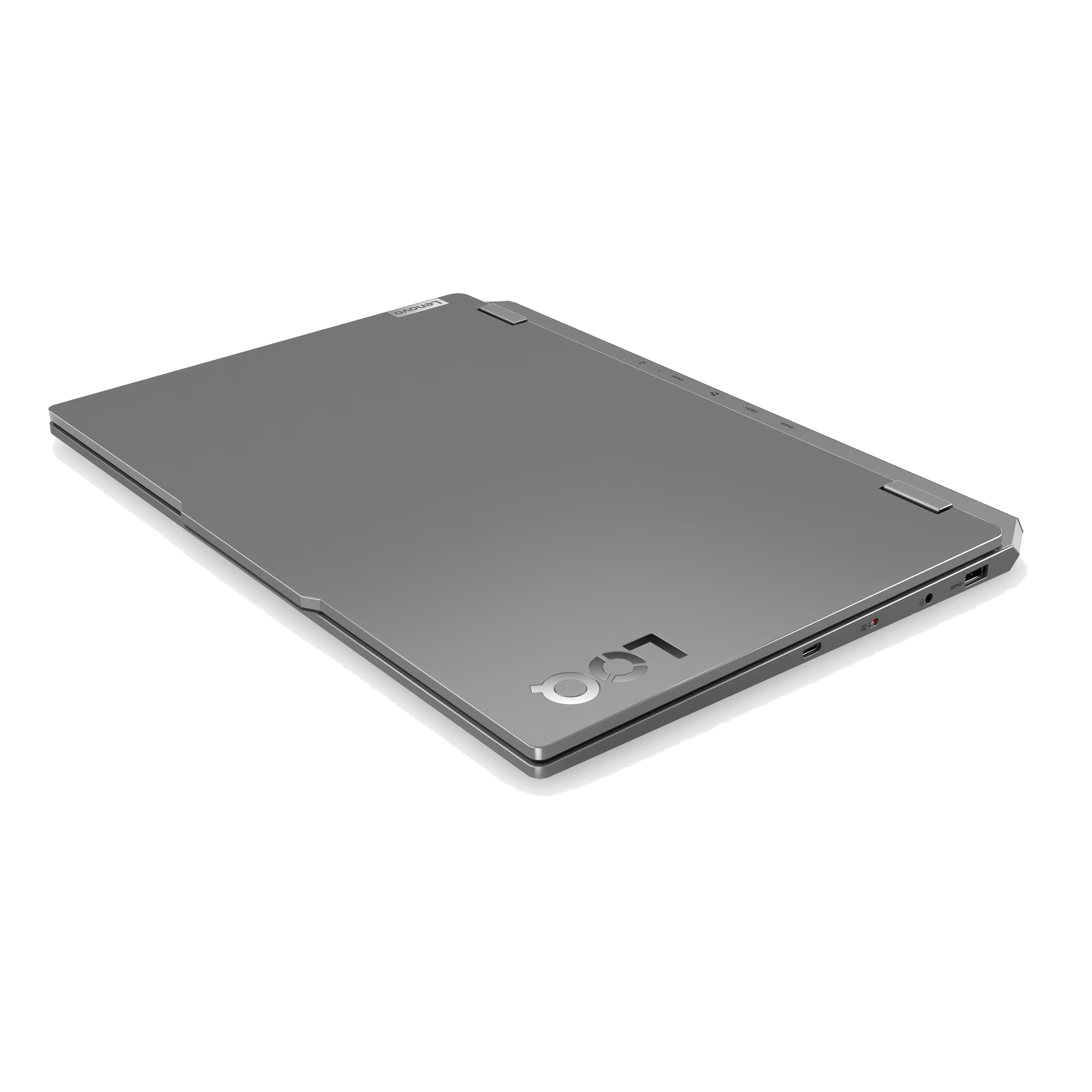 Un portátil gris cerrado sobre fondo negro con puertos visibles en el lateral.