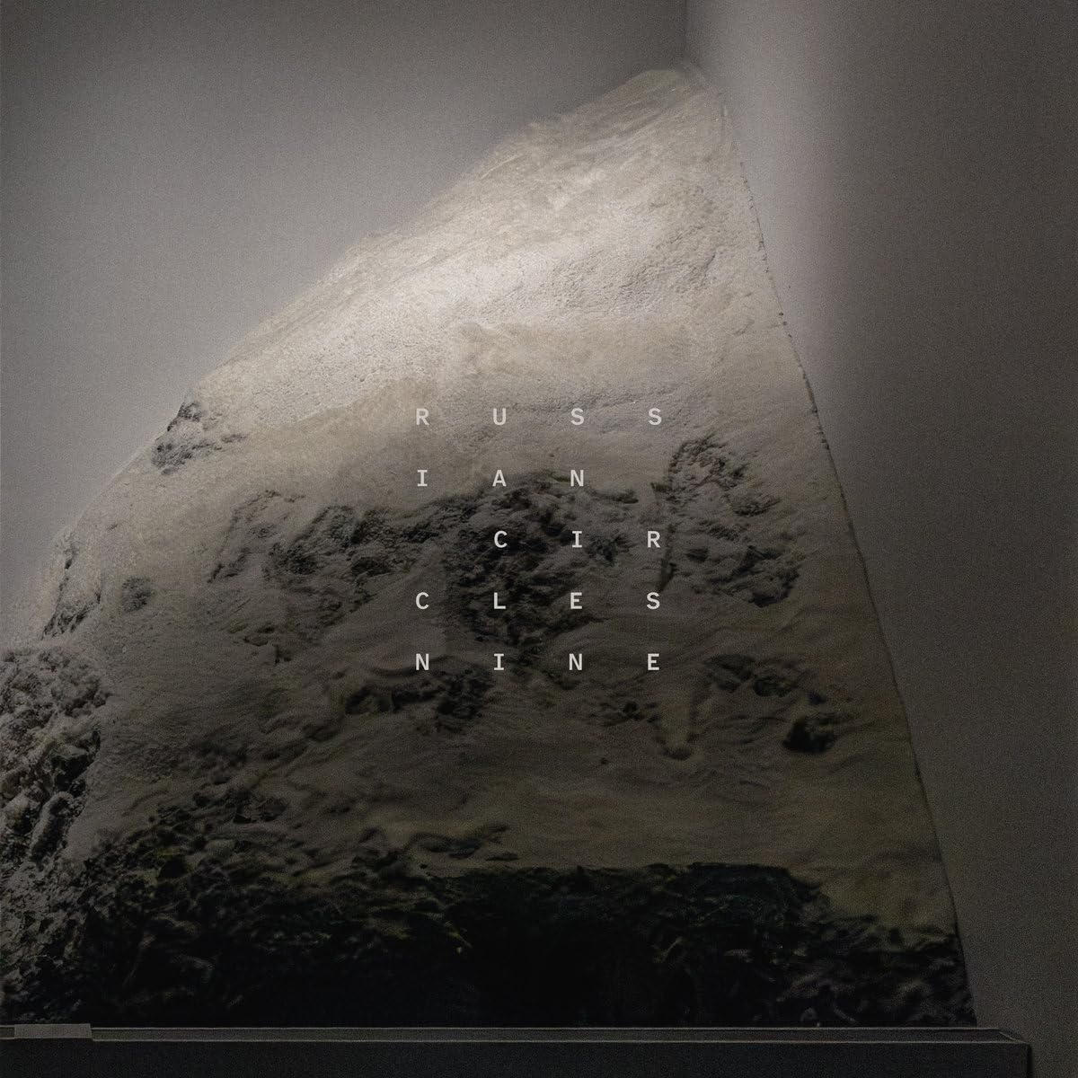 Eine raue, helle Felsskulptur in einer Ecke mit dem Text RUSSIAN CIRCLES in der Mitte.
