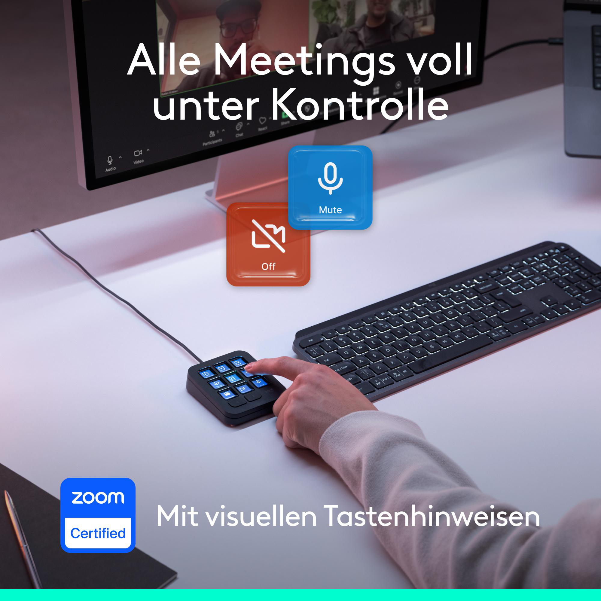 Hand drückt eine Taste auf einem kleinen Zusatztastenfeld vor einer Computertastatur und einem Monitor.
