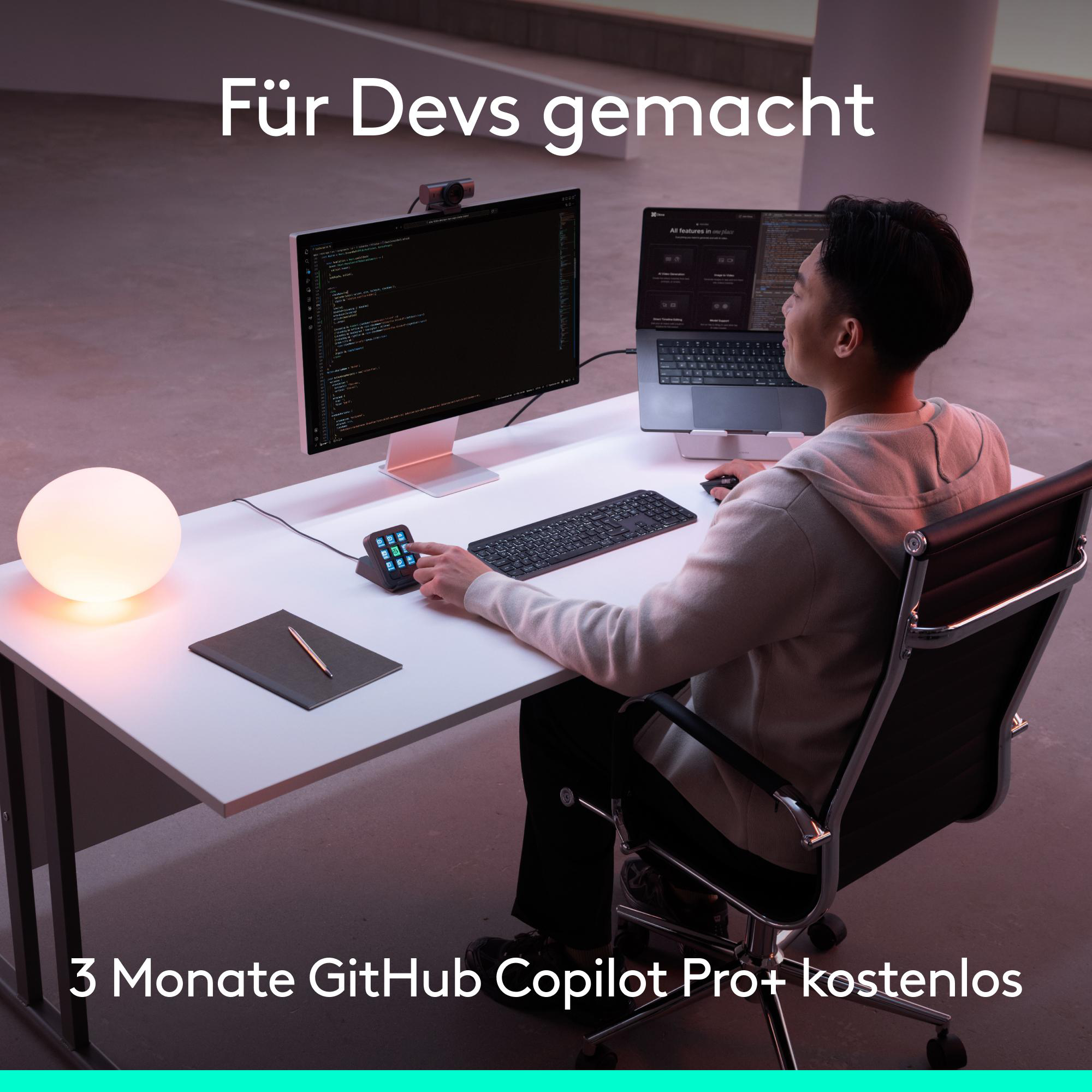 Entwickler arbeitet am Schreibtisch mit Monitor, Laptop und leuchtender Kugel.