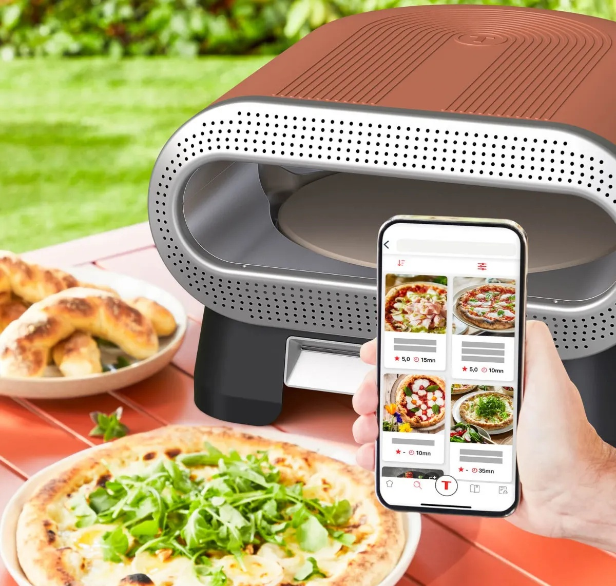 Nowoczesny zewnętrzny piec do pizzy z aplikacją i świeżą pizzą.