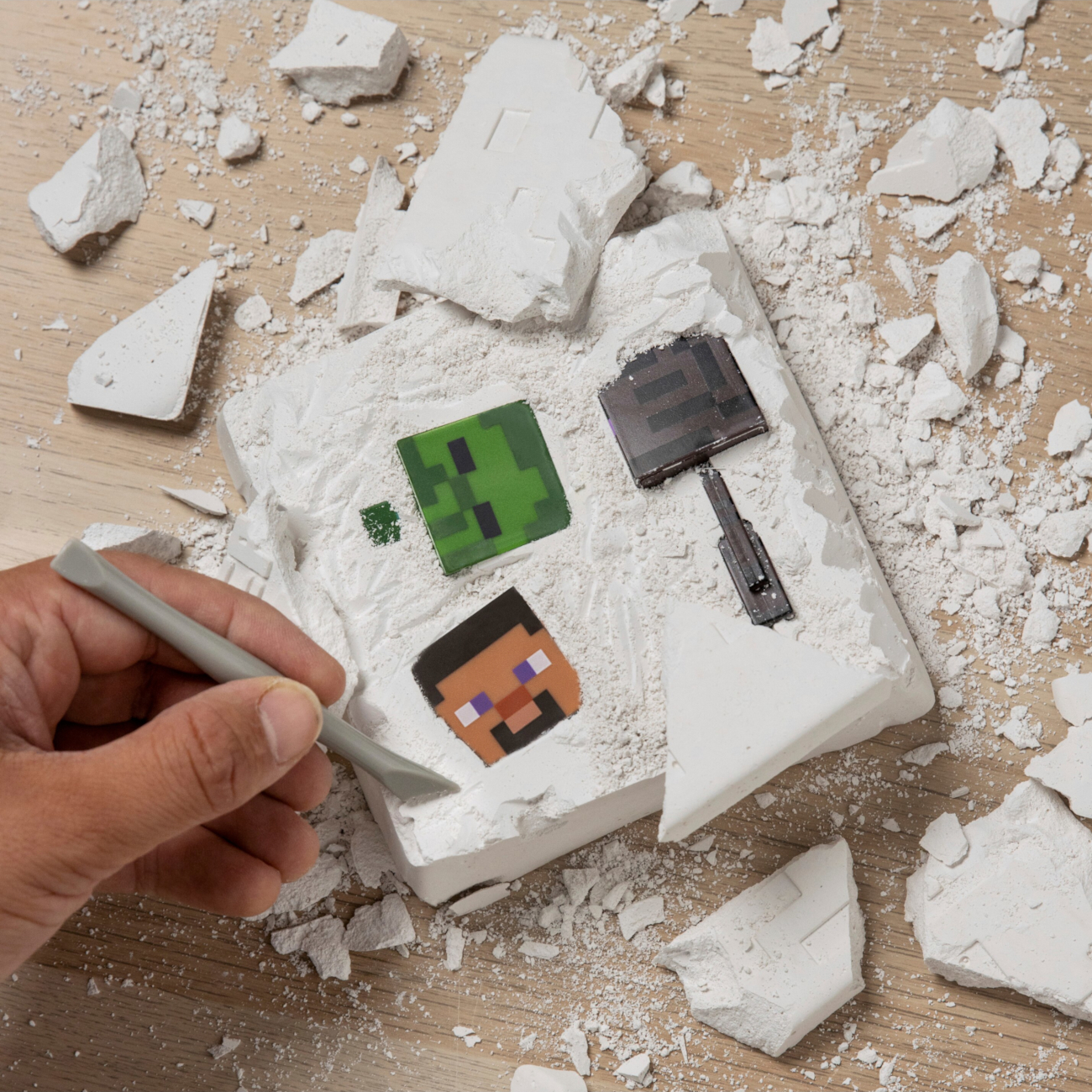 Kéz szerszámmal Minecraft figurákat ás ki fehér tömbből.