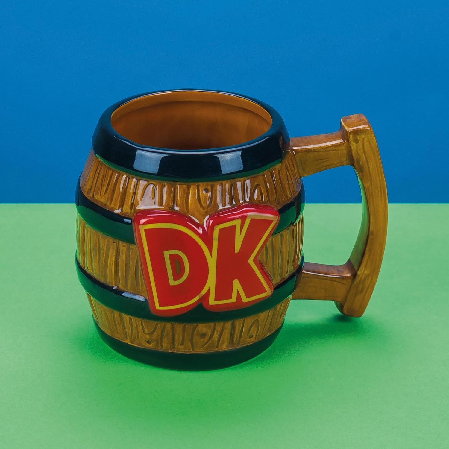 Hordoszeru keramia bongyo piros DK logoval, kek es zold hatter elott.