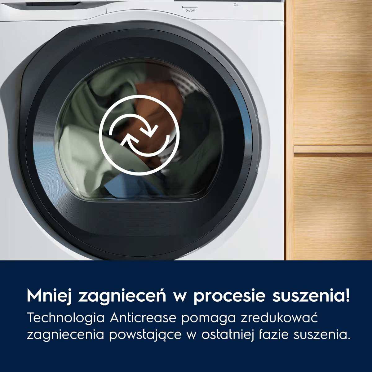 Biała pralka z obracającą się ikoną na szklanych drzwiach i kolorowym praniem w środku, obok drewnianych mebli.
