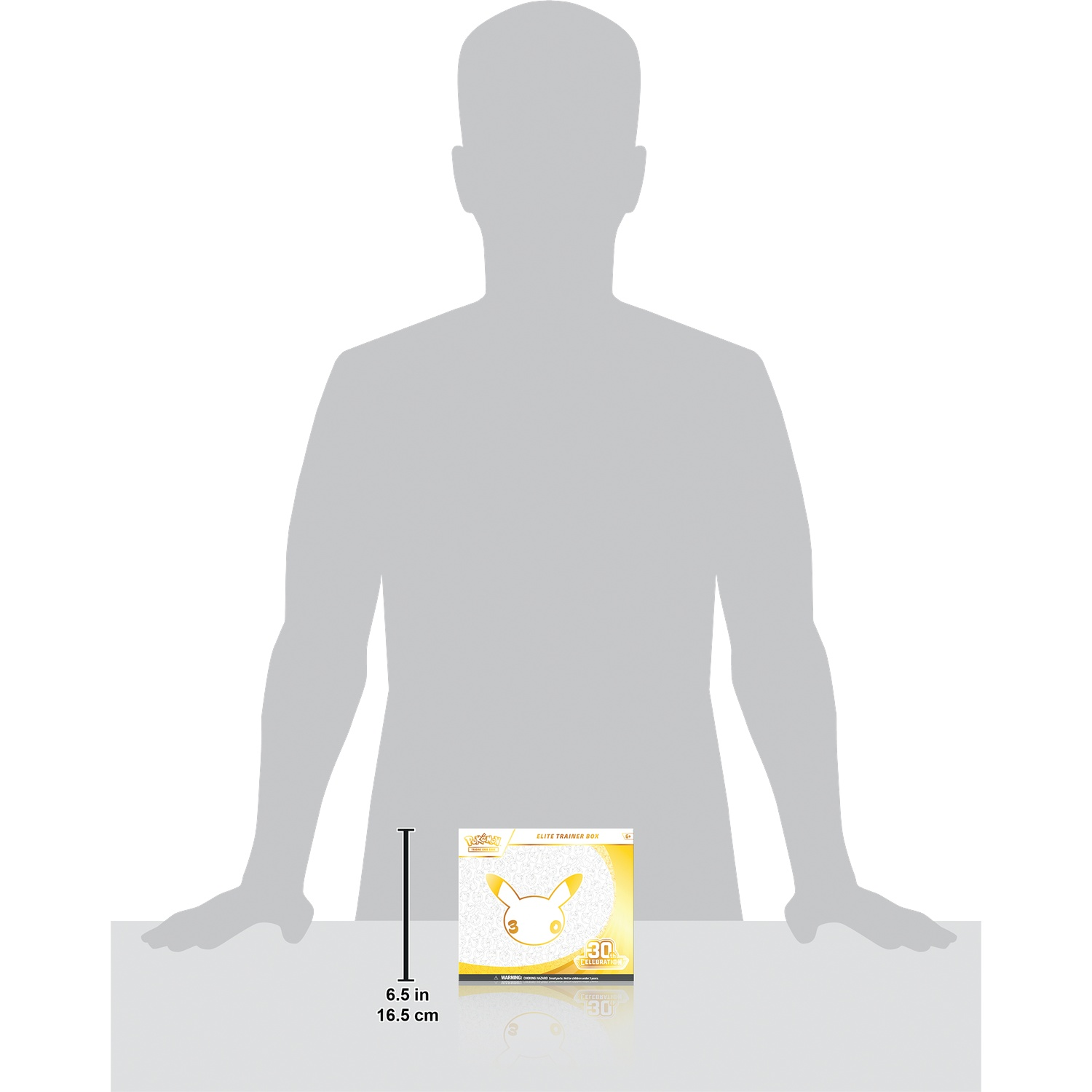 Een Pokemon Elite Trainer Box staat voor een grote grijze menselijke silhouet, met een hoogte van 6,5 inch.