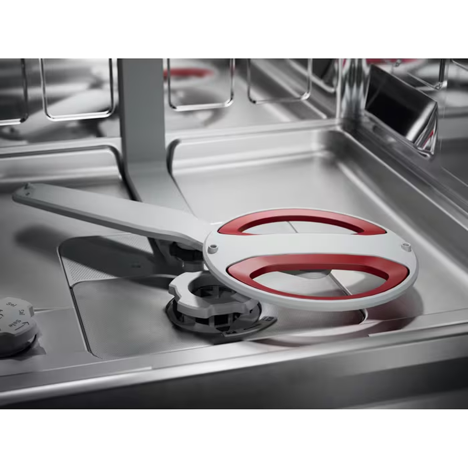 Close-up of a silver and red spray arm inside an empty stainless steel dishwasher.