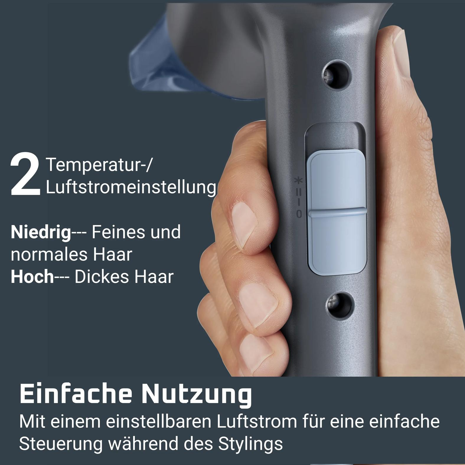 Hand hält einen grauen Haartrockner mit Schalter und deutschem Text für zwei Temperatureinstellungen.