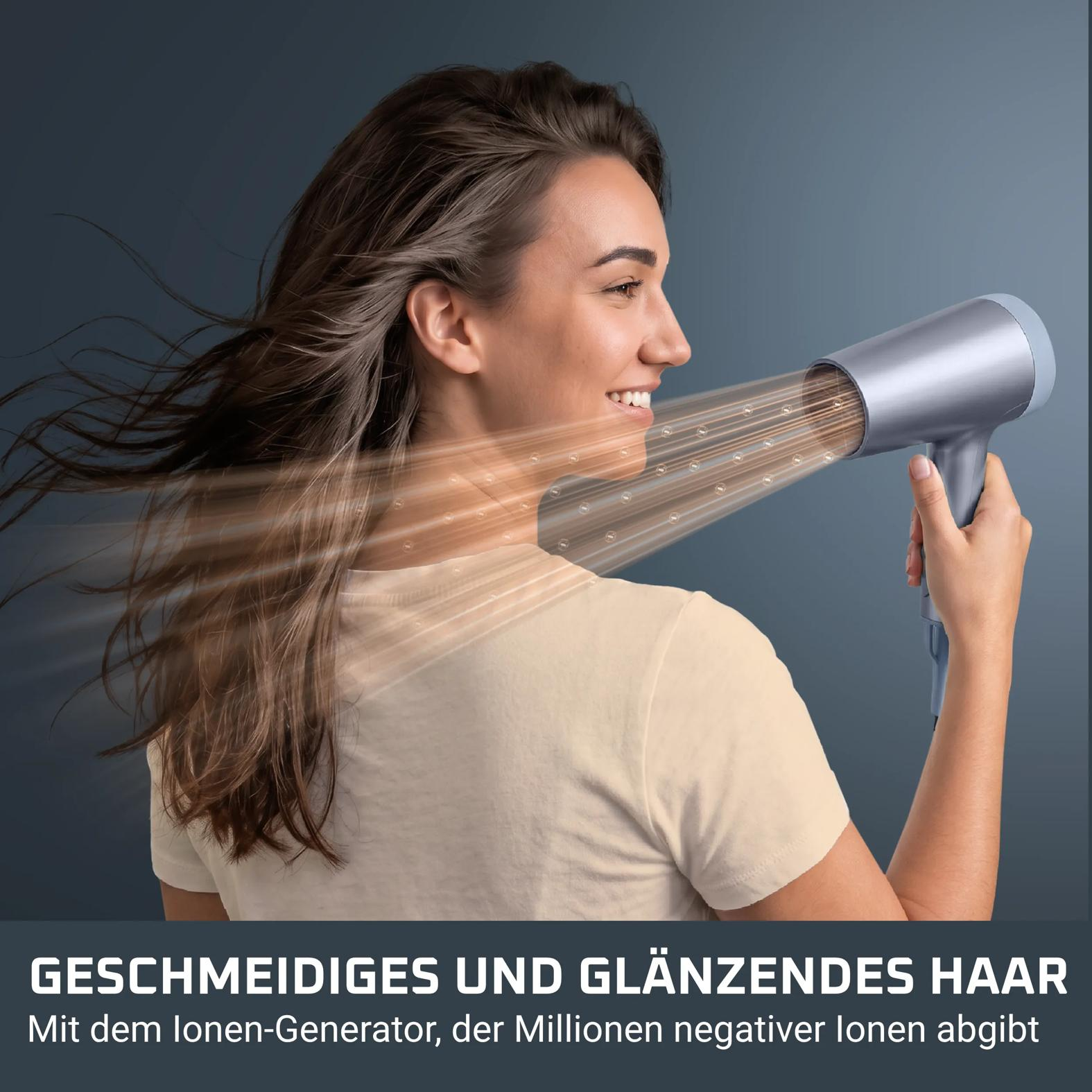 Eine Frau föhnt ihre Haare mit einem silbernen Haartrockner vor einem dunkelgrauen Hintergrund.