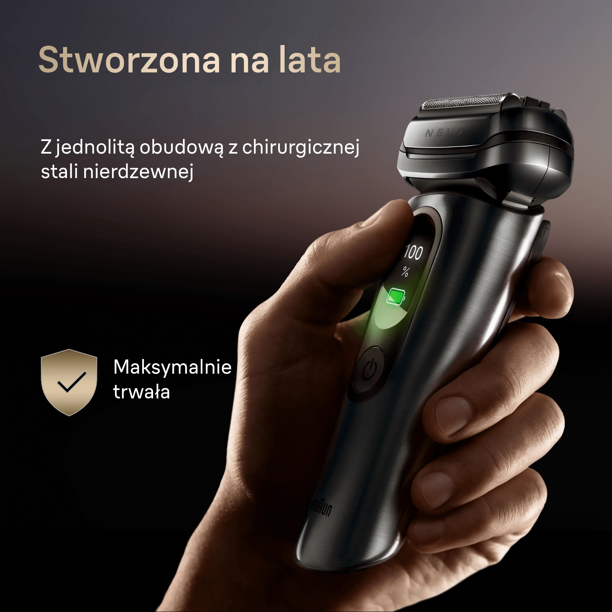 Dłoń trzyma metalową golarkę z cyfrowym wyświetlaczem baterii wskazującym 100 procent.