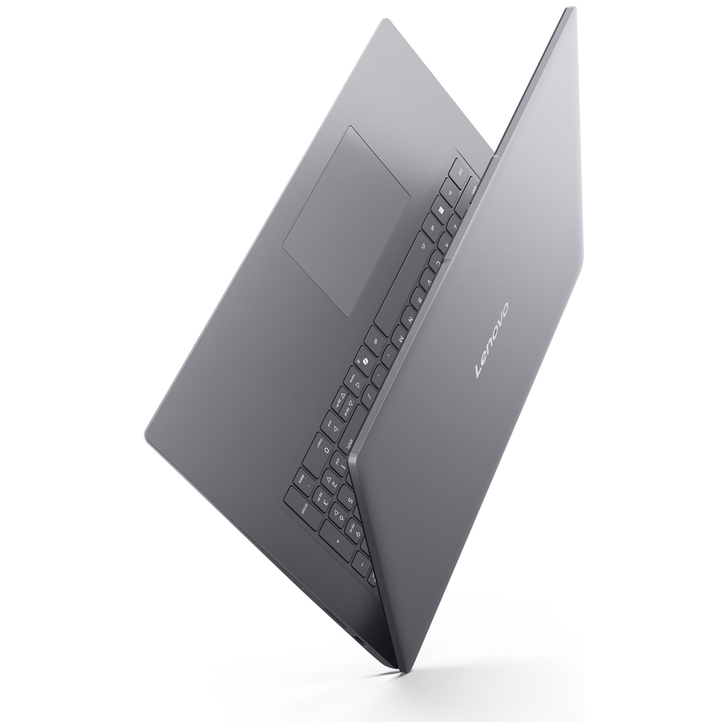 Un ordinateur portable Lenovo gris est posé de biais sur une surface blanche, montrant le clavier.