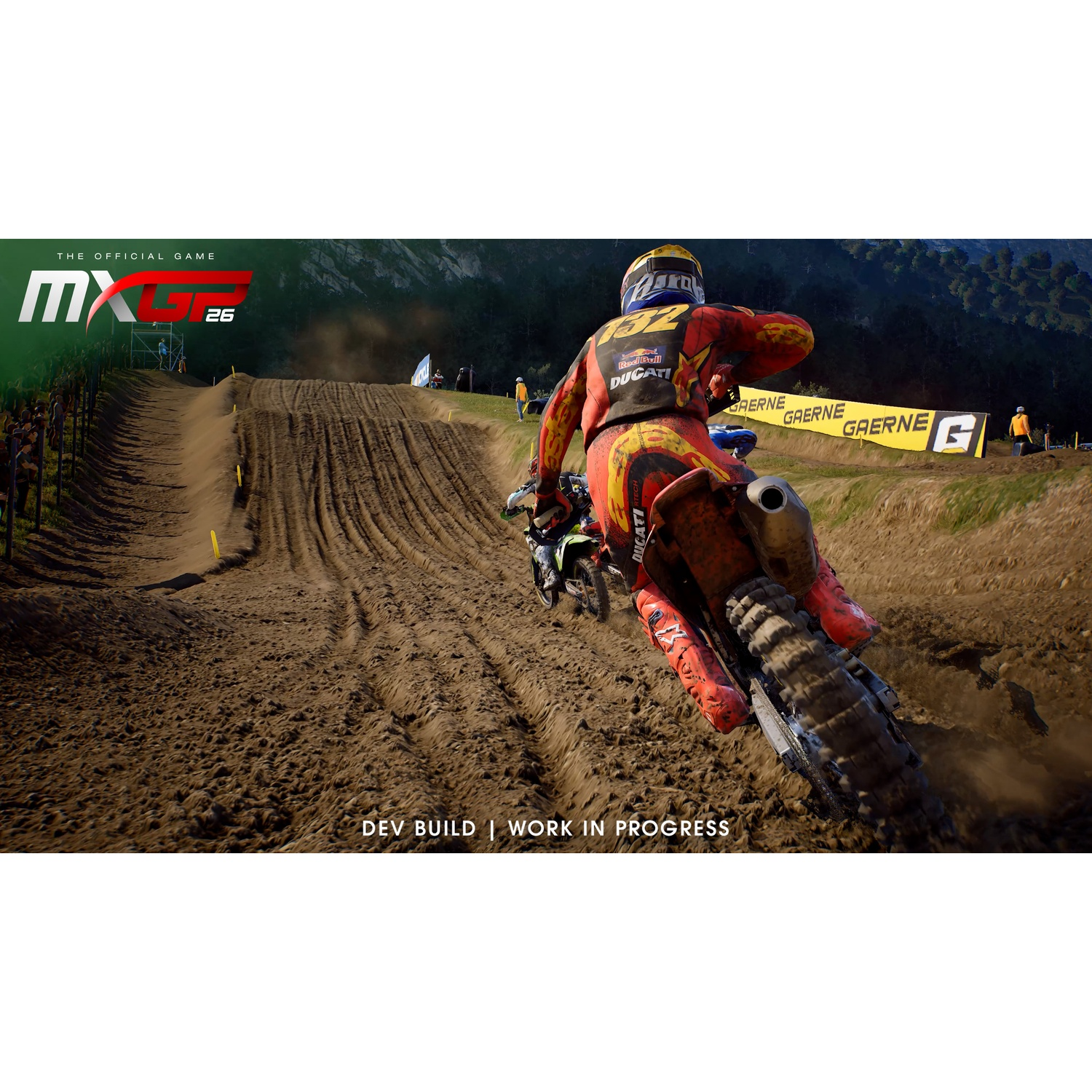 Un pilote de motocross en équipement rouge roule sur une piste de terre sablonneuse en extérieur.