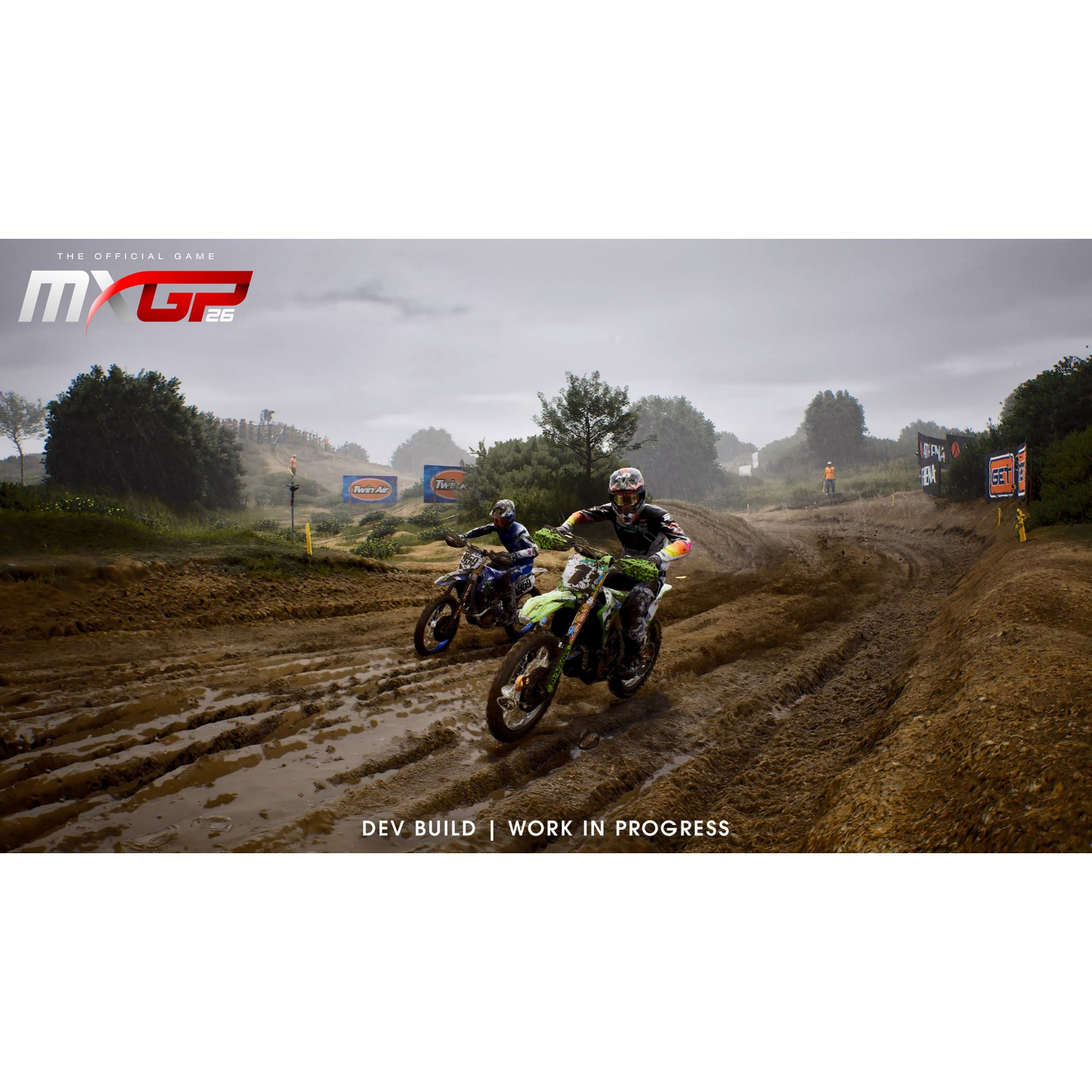 Deux motocyclistes de motocross faisant la course sur une piste boueuse sous un ciel nuageux.