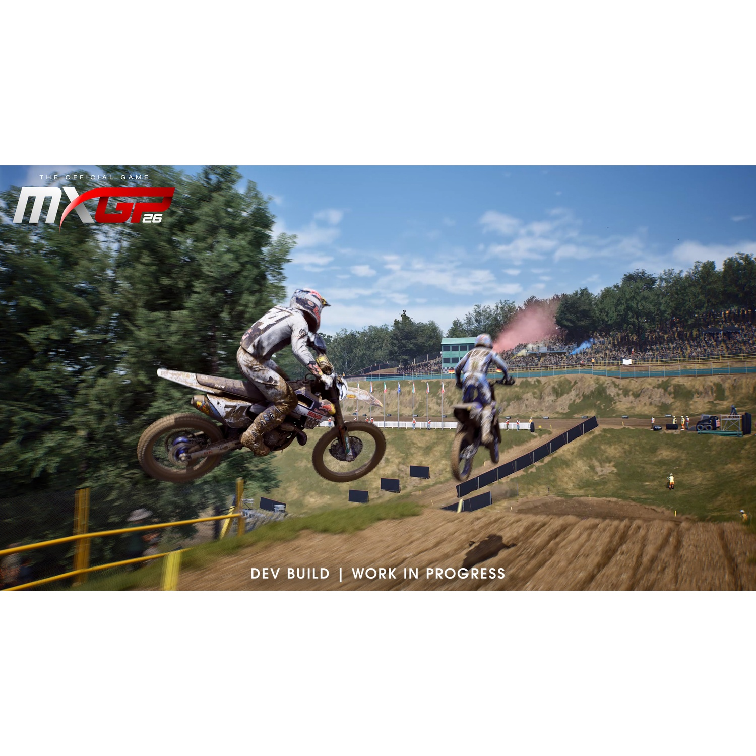 Deux pilotes de motocross sautent avec leurs motos boueuses sur une colline, avec un public et des arbres.