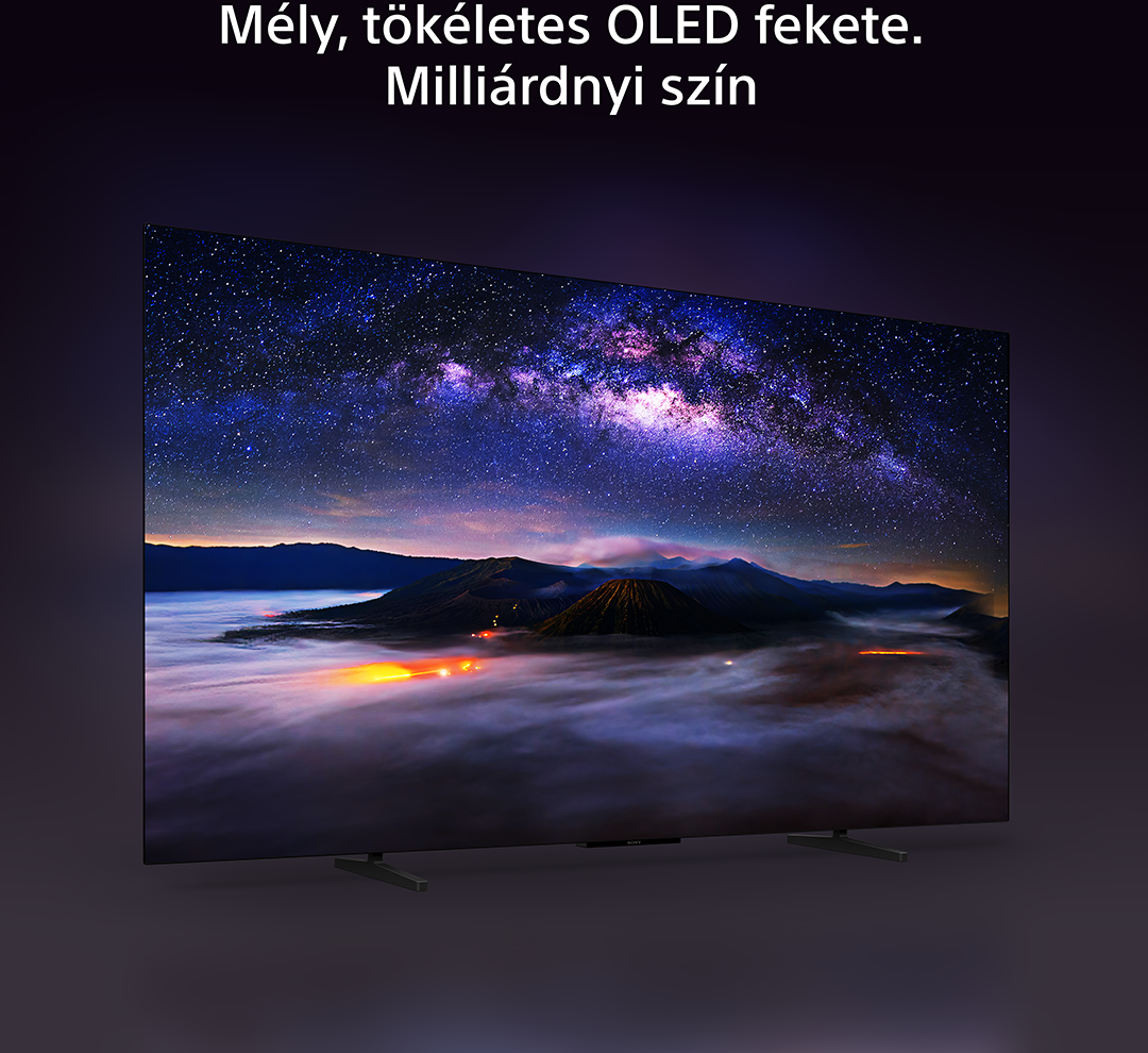 Egy OLED TV élénk éjszakai eget mutat hegyekkel és köddel, sötét háttér előtt.