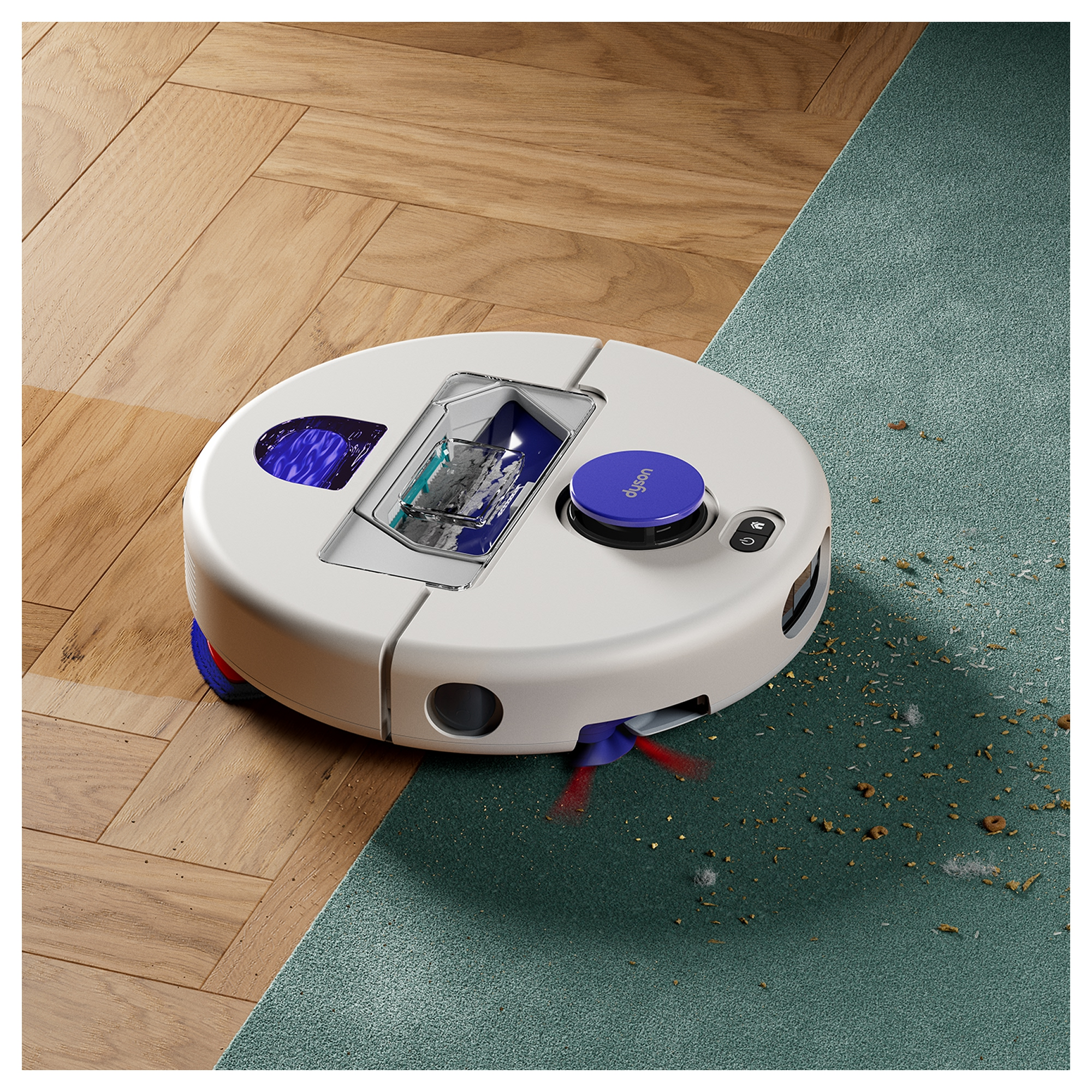 Ein weißer Roboterstaubsauger mit blauen Akzenten reinigt den Übergang von Holzparkett zu einem grünen Teppich mit Krümeln.