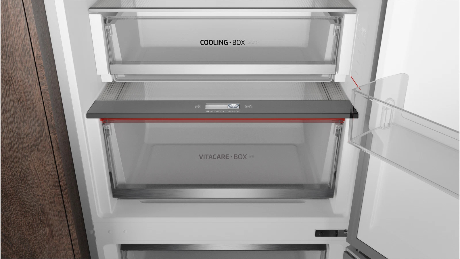 Wnętrze otwartej lodówki z szufladami Cooling Box, Vitacare Box i kontrolą wilgotności.