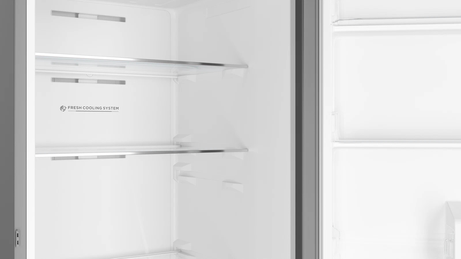 Wnętrze nowoczesnej, pustej białej lodówki z regulowanymi półkami i napisem Fresh Cooling System.