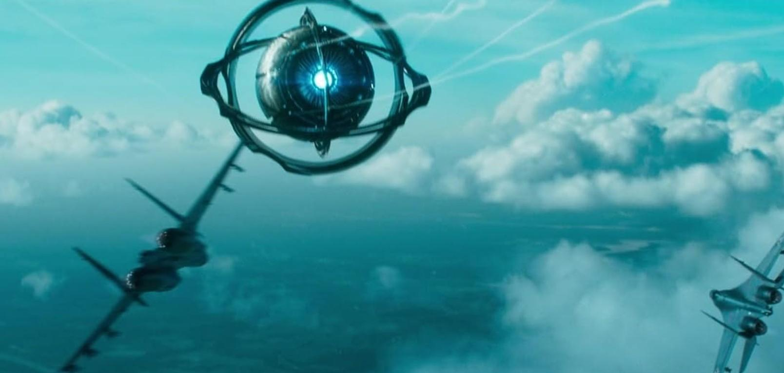 Eine futuristische sphärische Maschine schwebt am blauen Himmel über Kampfjets, mit Wolken im Hintergrund.