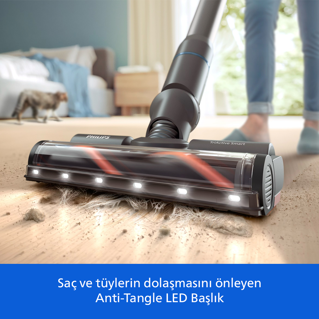 LED ışıklı bir Philips süpürge, aydınlık bir odada ahşap zemindeki saç ve kirleri çekiyor.