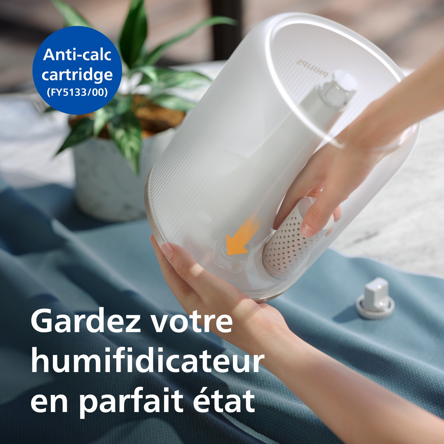Une personne insère une cartouche anti-tartre blanche dans un réservoir d'eau.