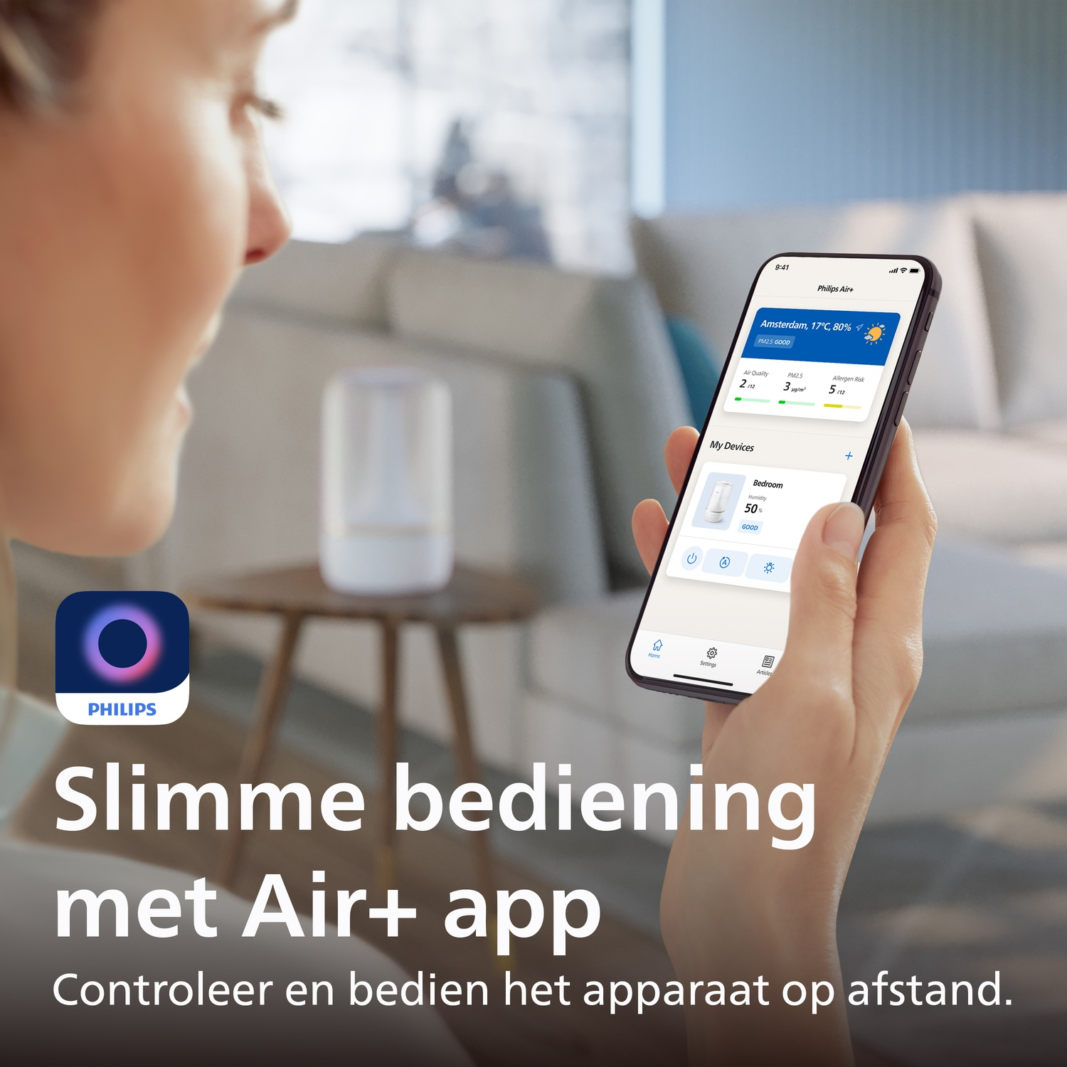 Person holding a smartphone with the Philips Air+ app, with a living room in the background.