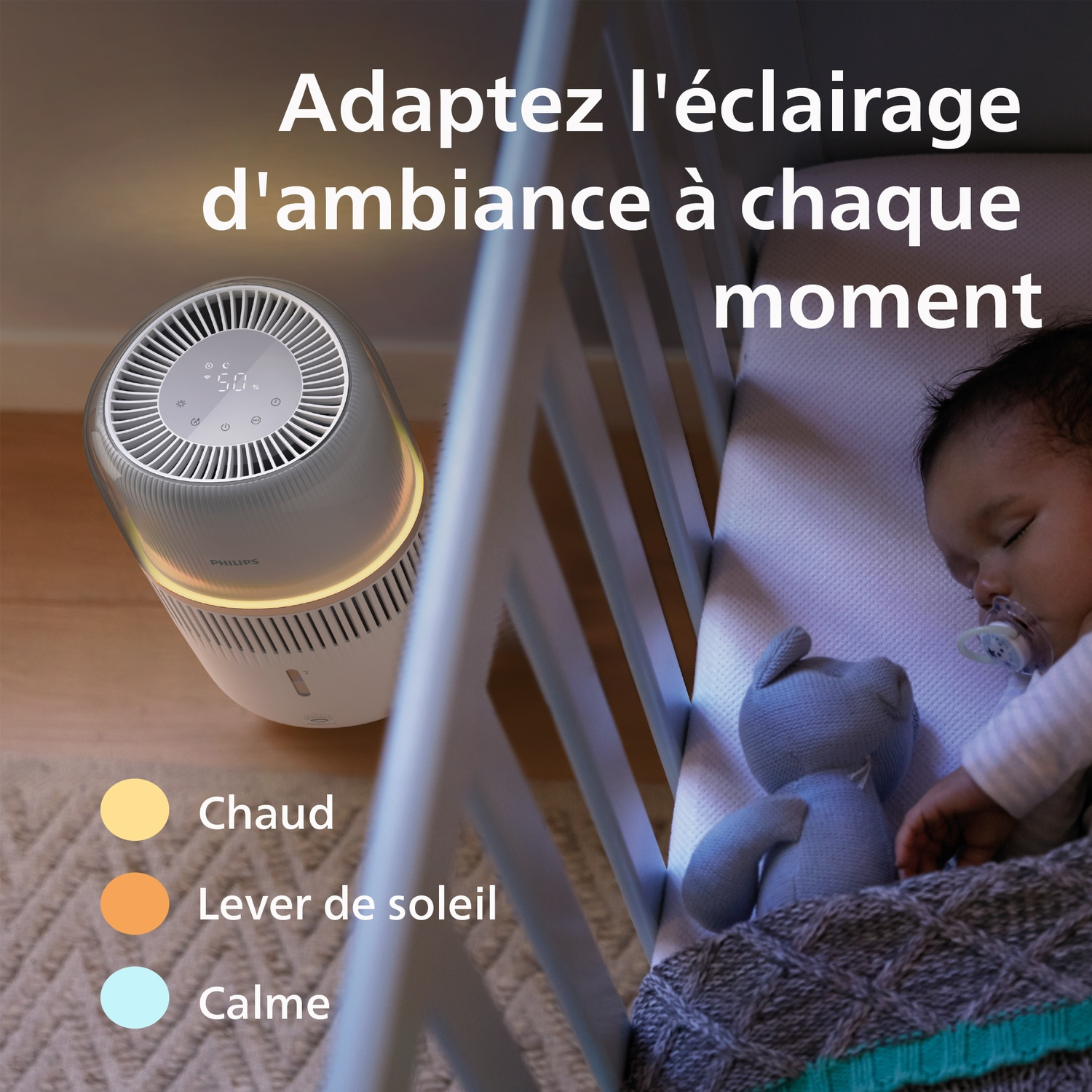 Un bébé dort dans un lit à côté d'un purificateur d'air Philips lumineux.