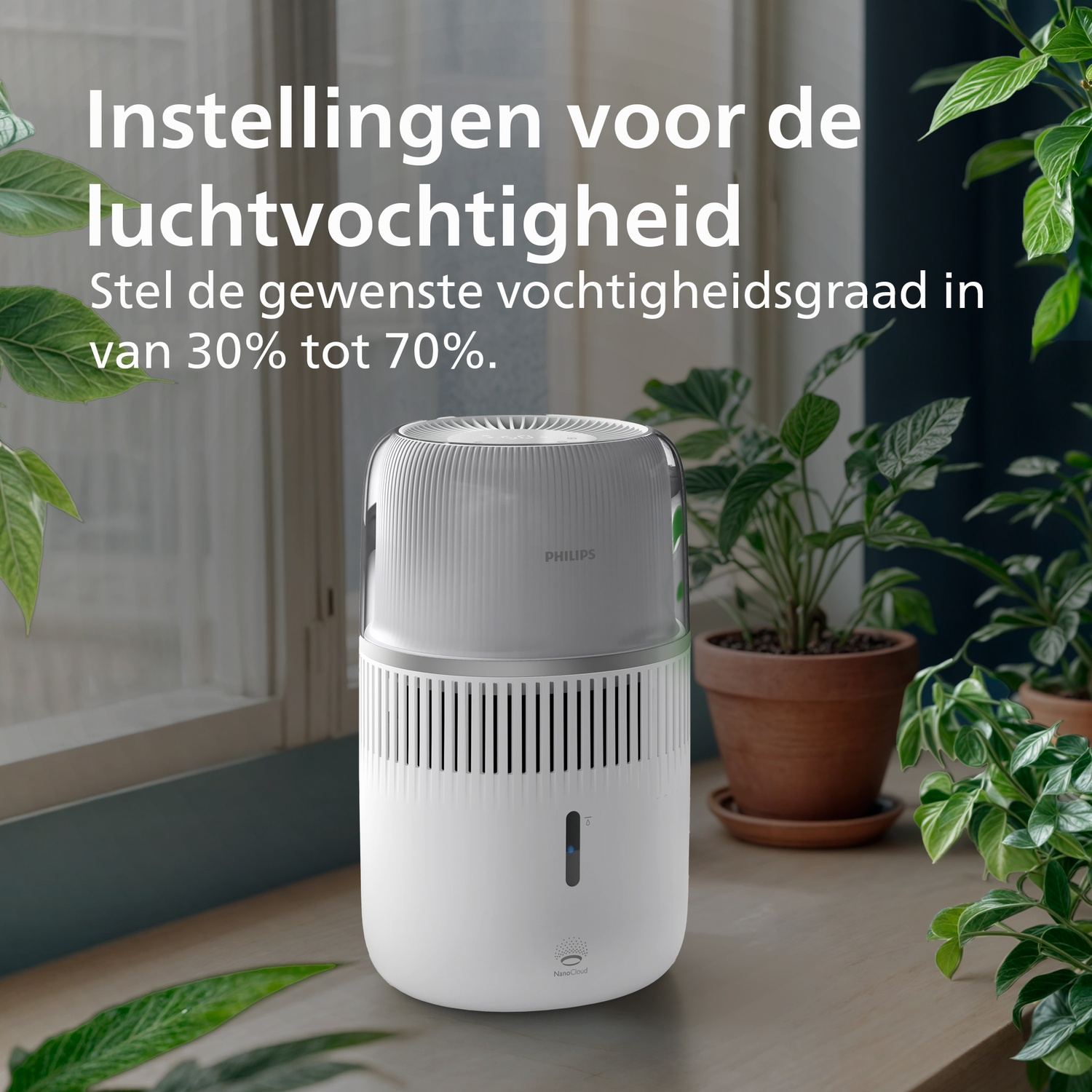Een witte Philips luchtbevochtiger staat op een houten oppervlak met groene planten en Nederlandse tekst.