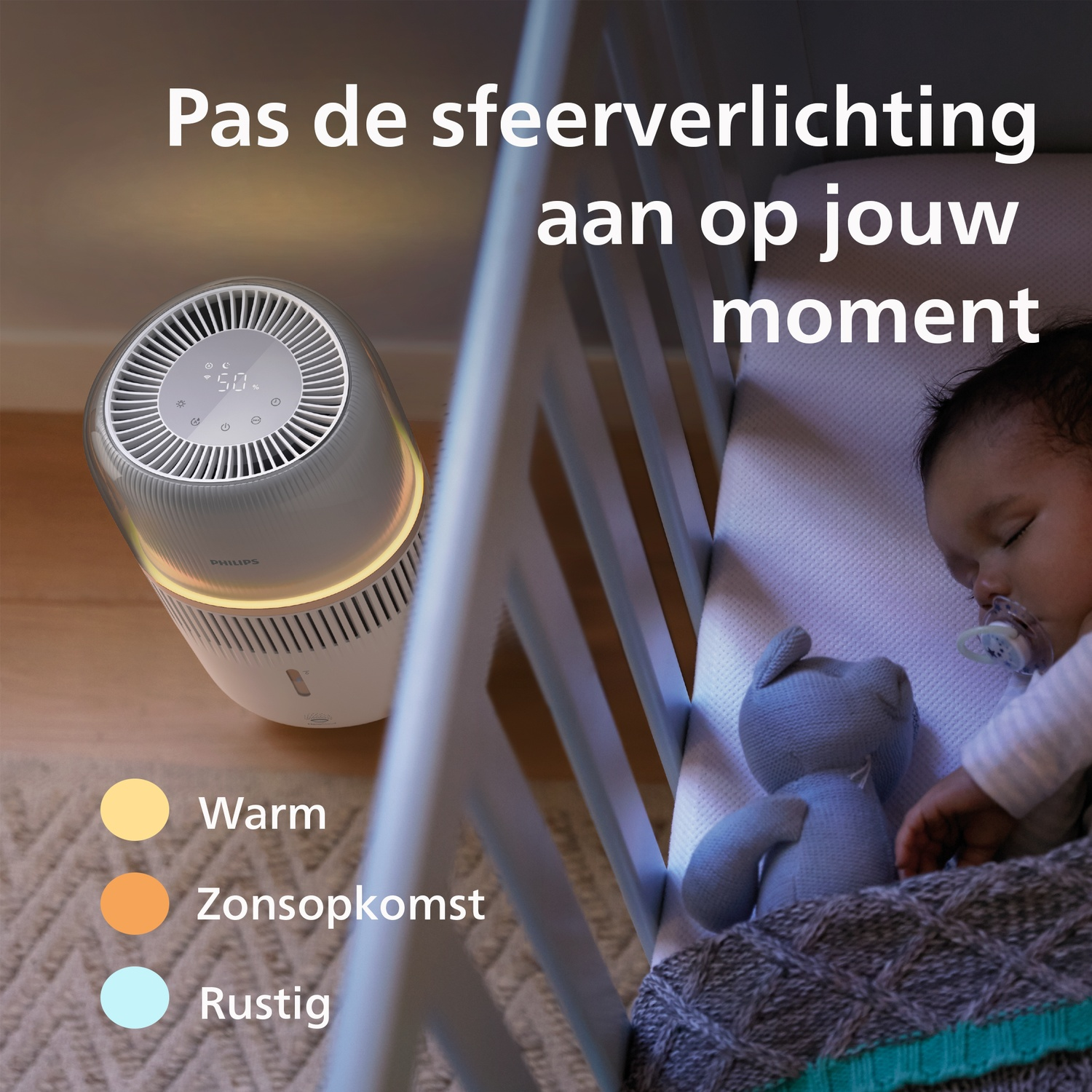 Een Philips-luchtbevochtiger gloeit naast een ledikantje waar een baby slaapt.