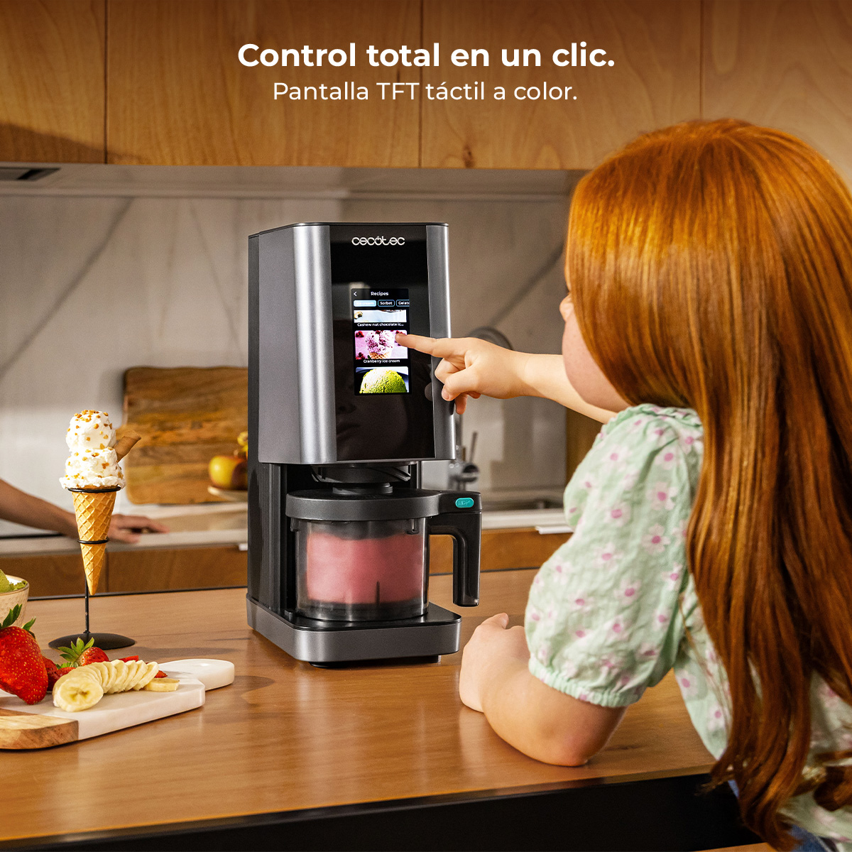 Una niña toca la pantalla táctil de una heladera moderna en una cocina.
