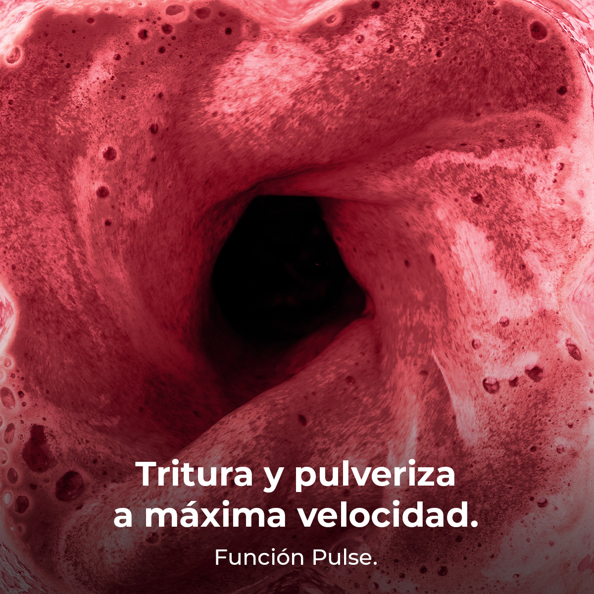 Batido rojo licuándose dentro de una batidora, con el texto Tritura y pulveriza a máxima velocidad.